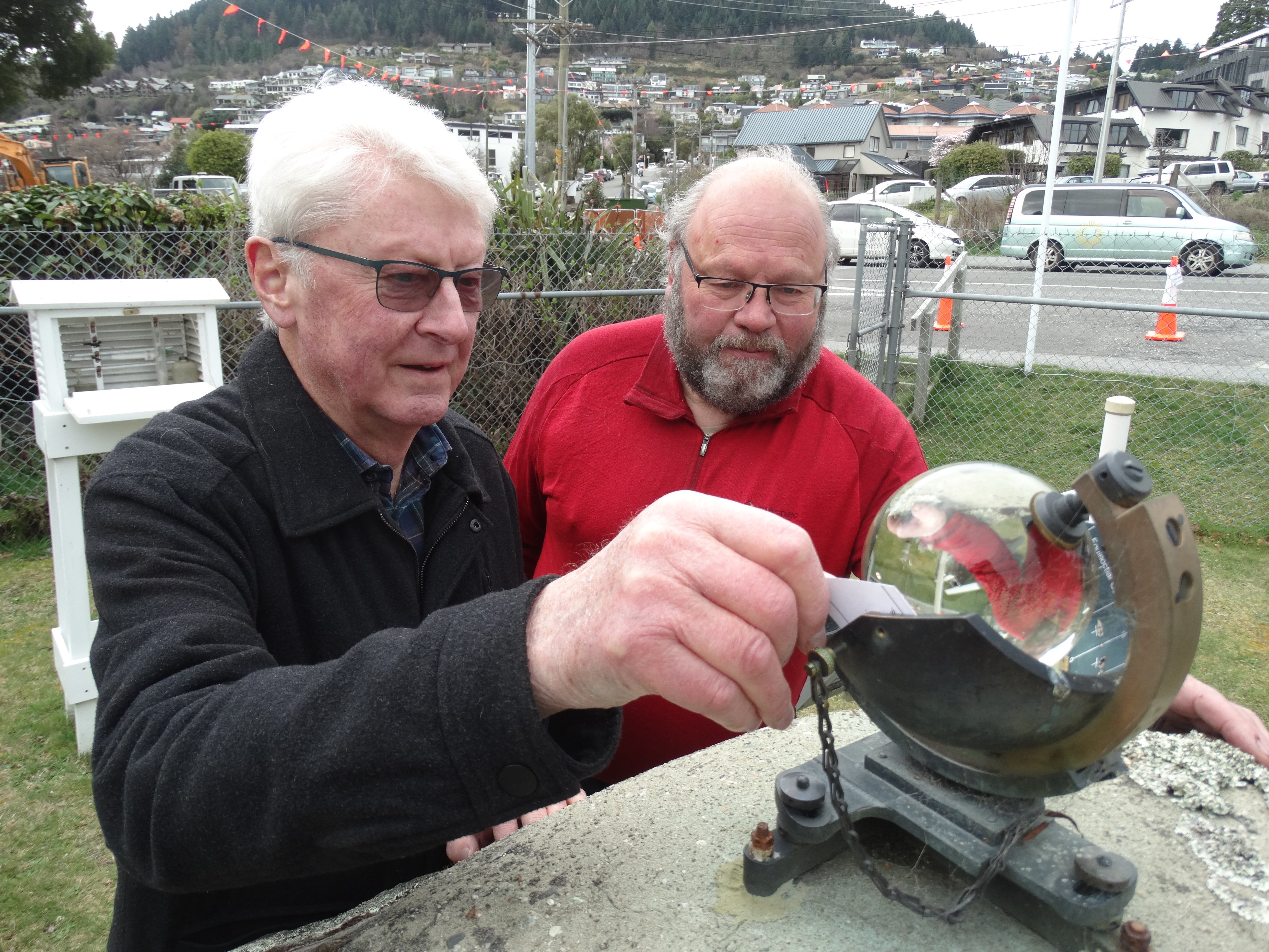 Queenstown residents Stuart Maclean, left, and Robert Taylor check the sunshine recorder at the...