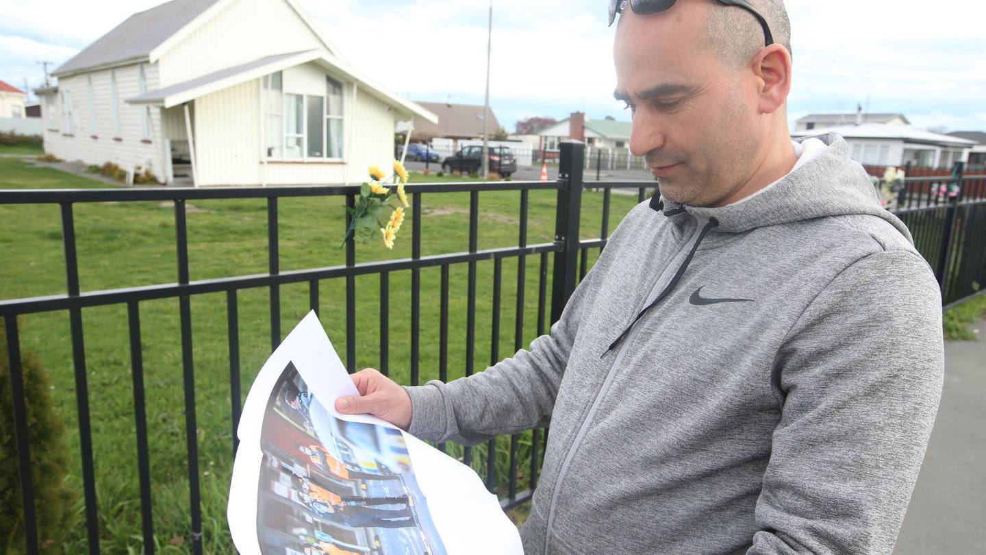 El Ouafi Aghoutan glances at a photo of the aftermath of last week's terror attack. Photo: Adam...