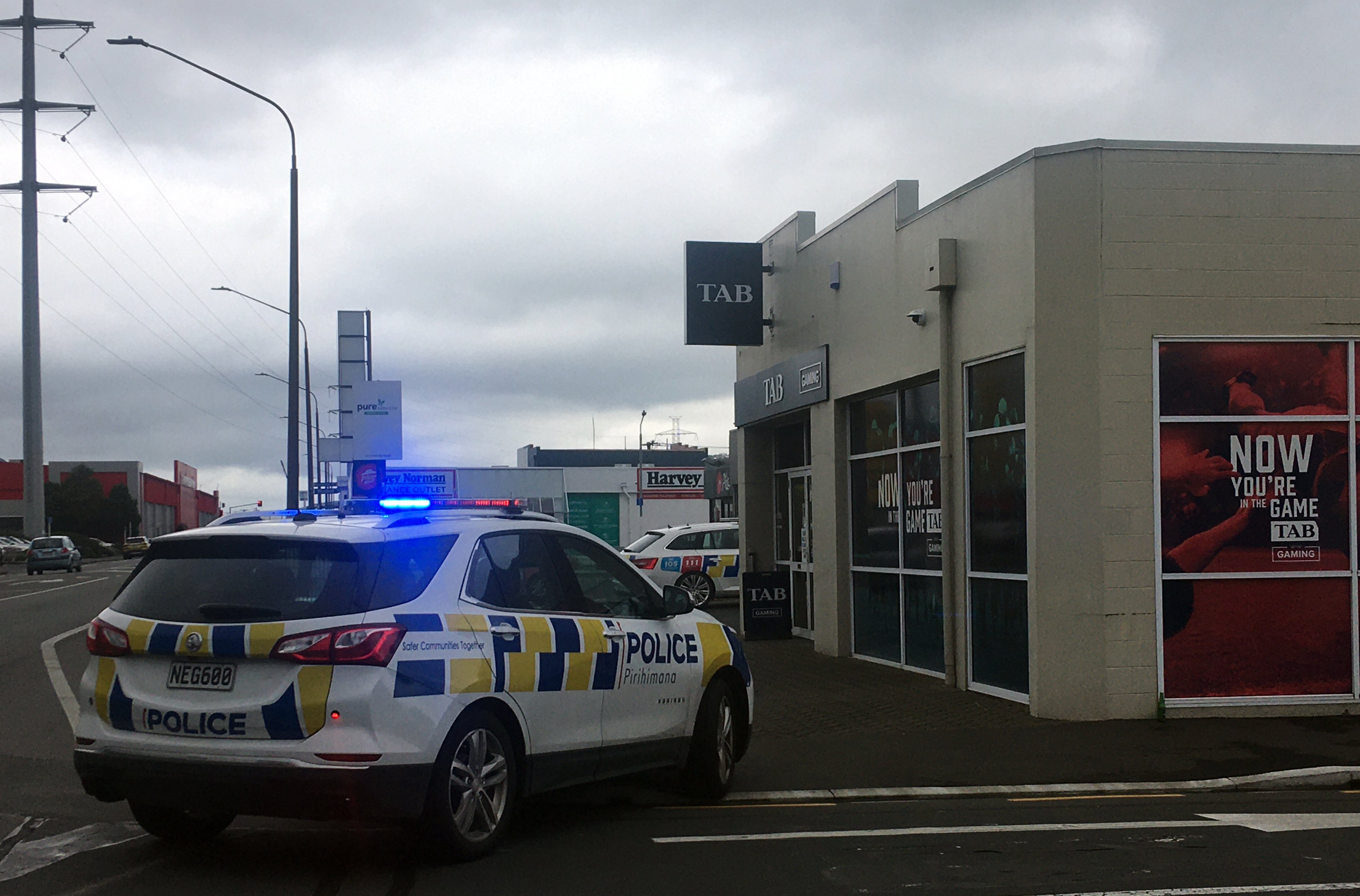 Police investigate a robbery at the TAB outlet in Hillside Rd, South Dunedin, yesterday. PHOTO:...