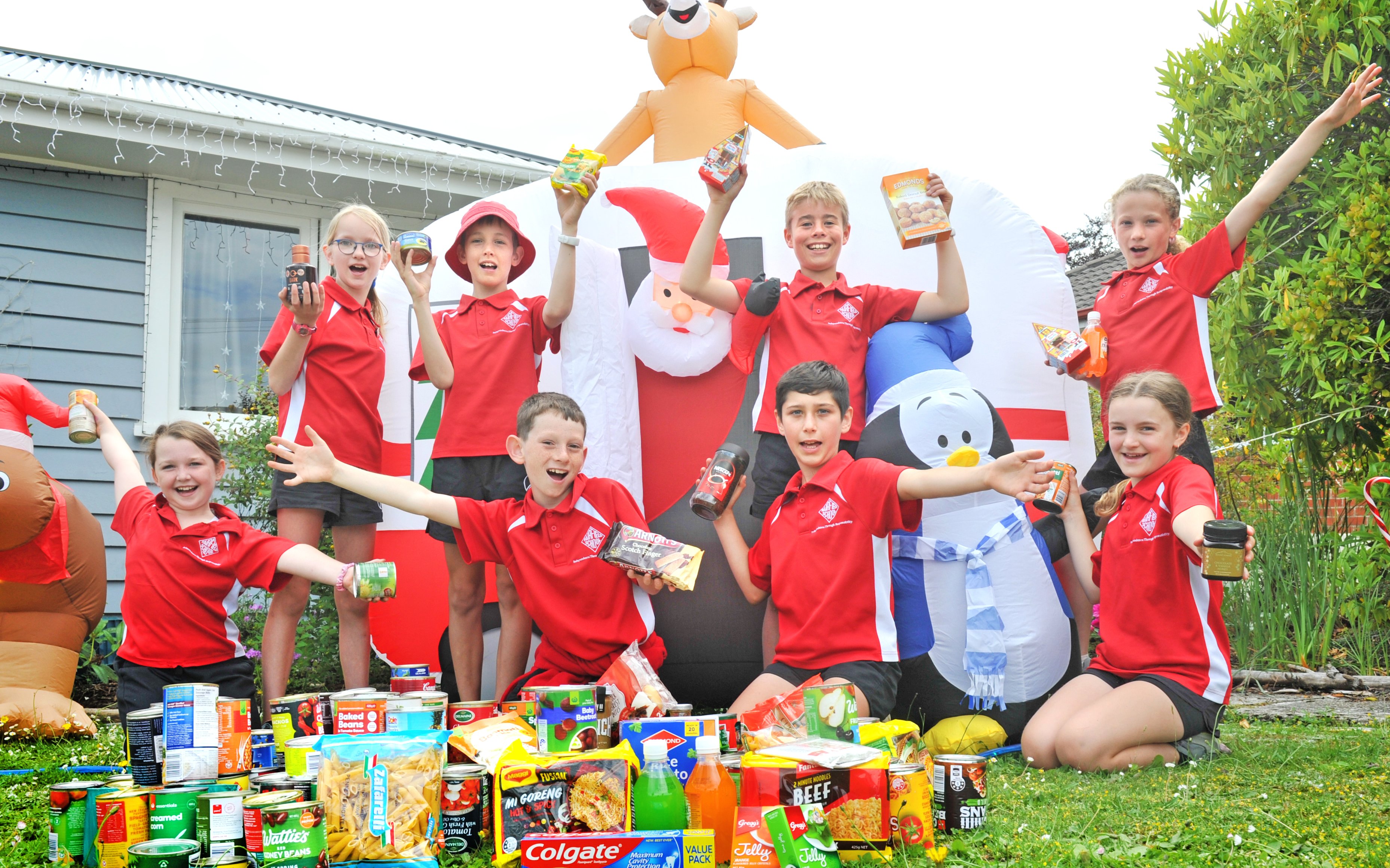 Holding up food to be given to Dunedin foodbanks are Fairfield School pupils (back, from left)...