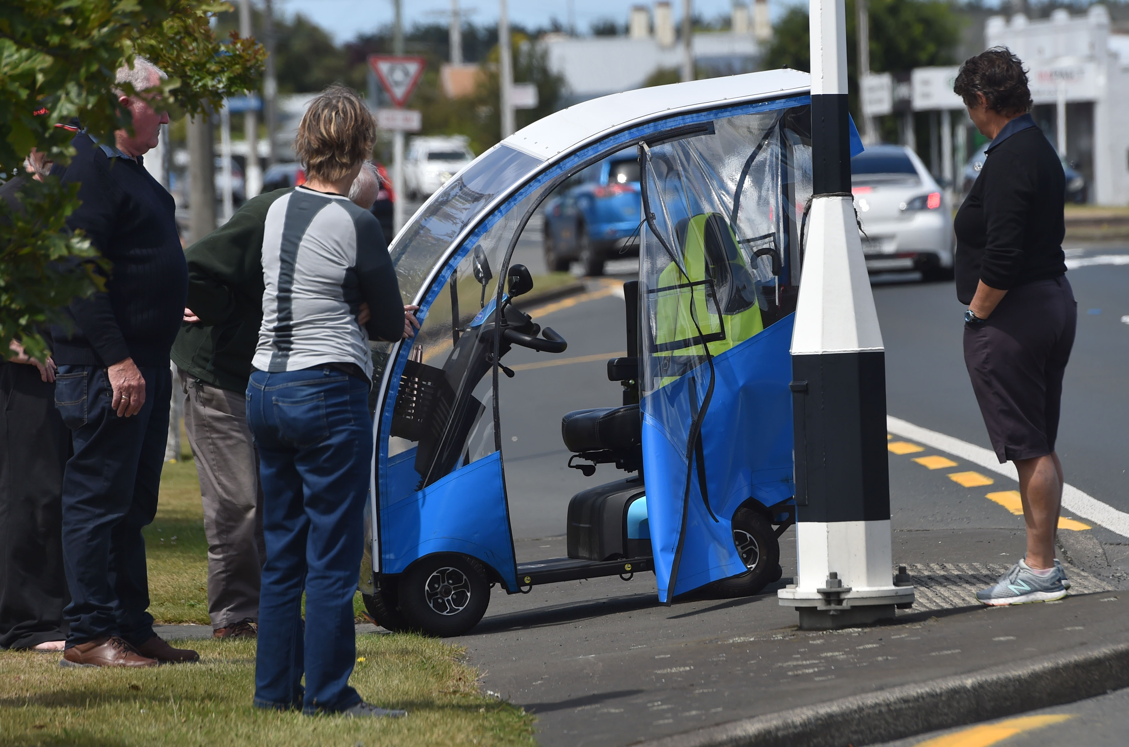 A man in an electric mobility scooter is attended at the scene by witnesses who saw him get...