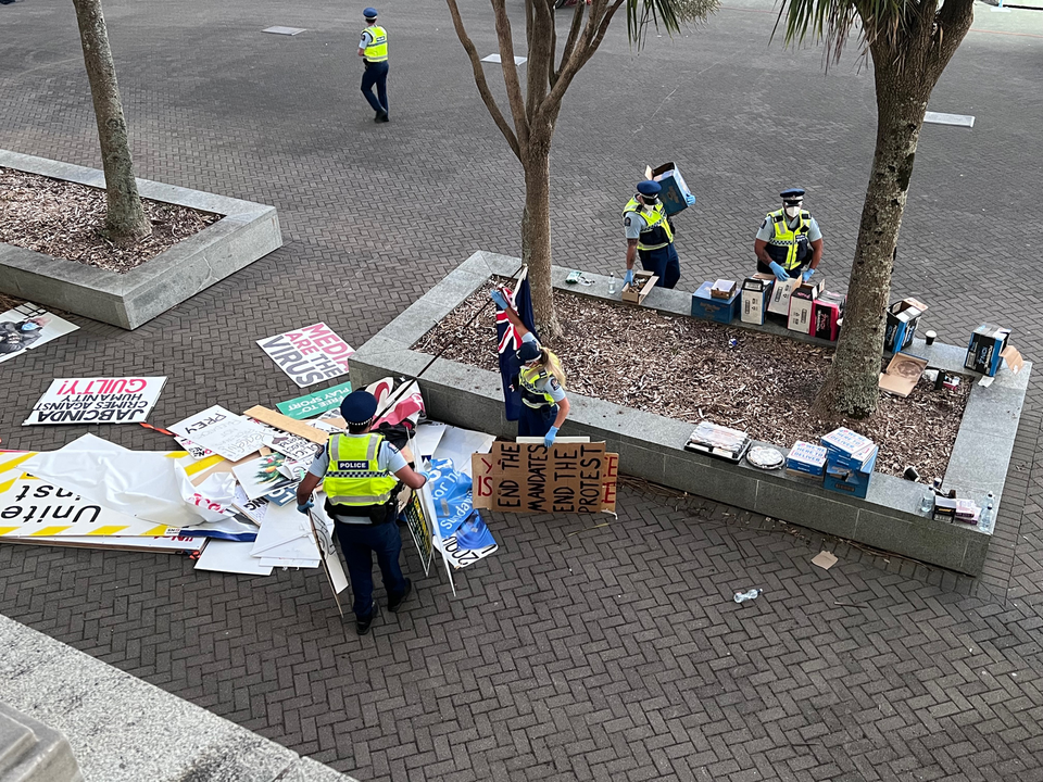 Police clear signs from Parliament's forecourt this morning. Photo: RNZ