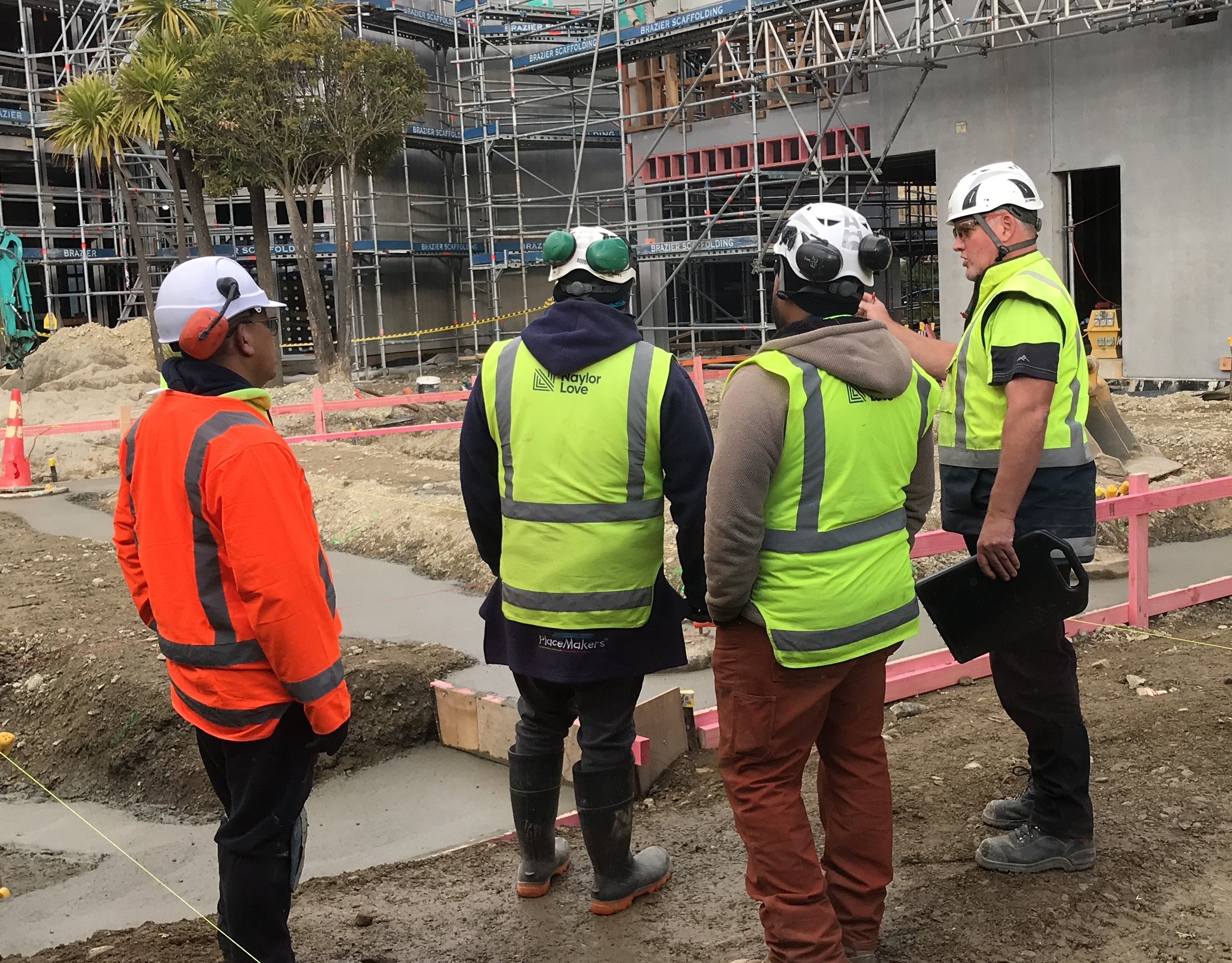 Naylor Love construction workers discuss the site for the school’s new whare, the foundations of...