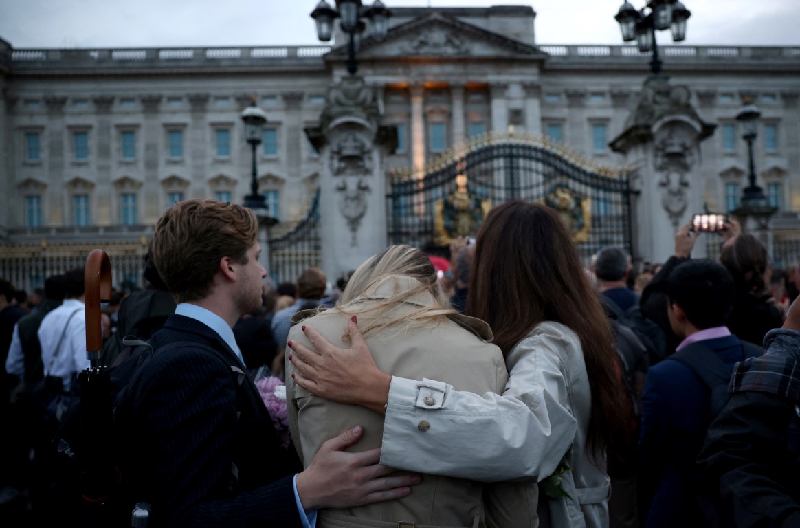 People gather outside Buckingham Palace in Londan after it was announced that Queen Elizabeth had...