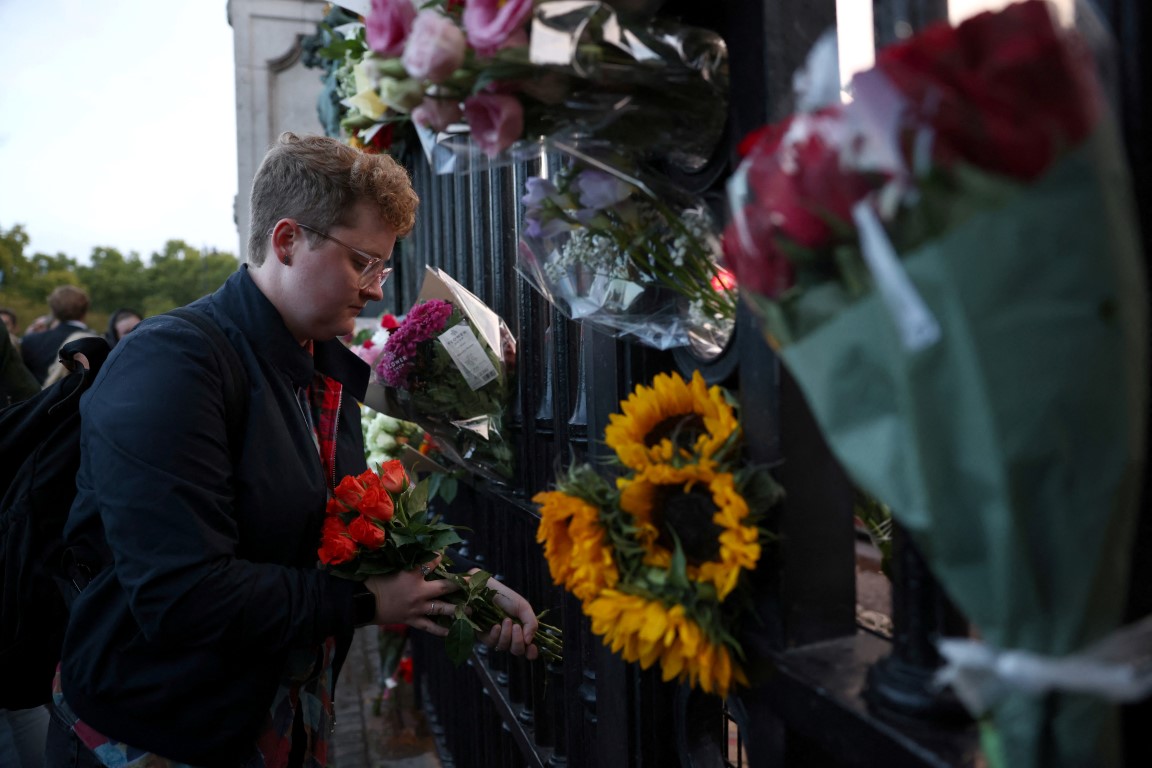 A man places flowers outside Buckingham Palace as a tribute to Queen Elizabeth. Photo: Reuters