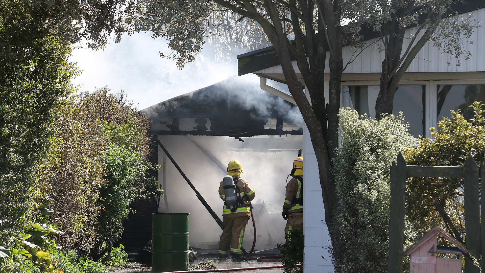 Under control . . .Rangiora Volunteer firemen dampen down a garage blaze in Boyd Street Rangiora....