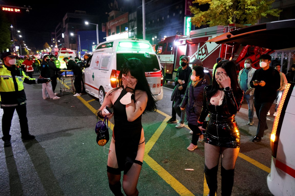 Partygoers walk by ambulances at the scene of the stampede in Seoul. Photo: Reuters