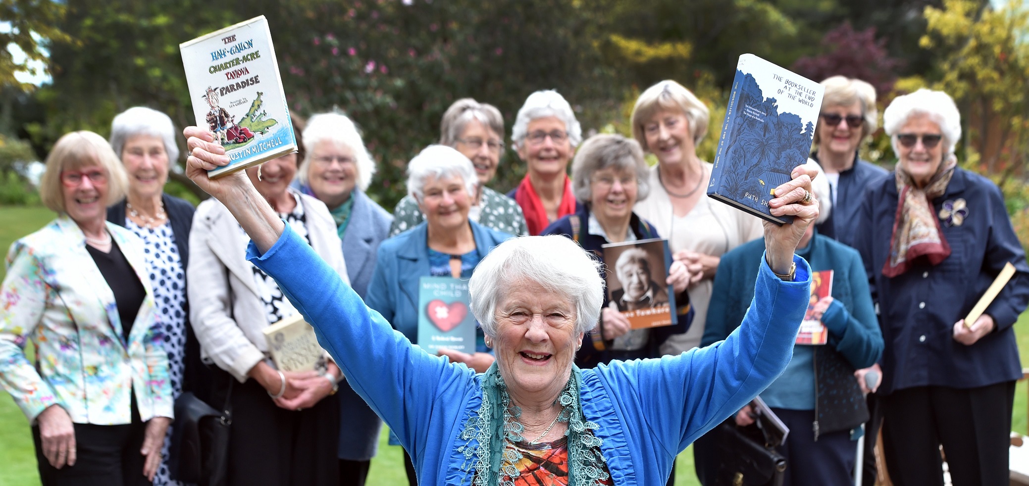 Chota Moore and members of the book club hold up one of the first and most recent books read by...