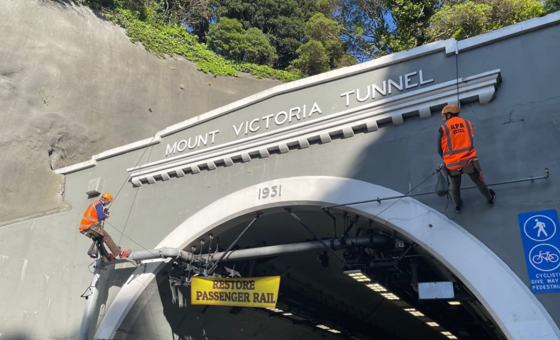 Two protesters from the Restore Passenger Rail group have abseiled down the Hataitai side of the...