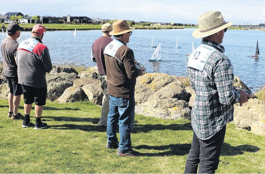 Eyes on the lake . . . Skippers watch their one metre long radio controlled sail boats manoeuvre...