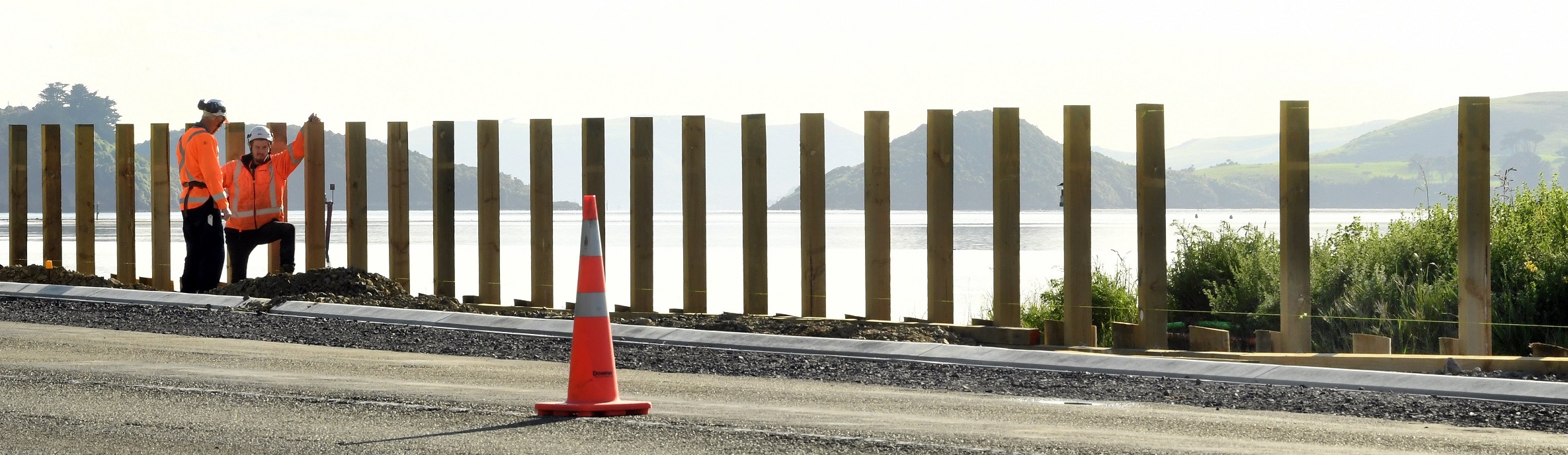 Workmen construct a 1.4m fence beside the Port Chalmers cycleway. Photo: Stephen Jaquiery