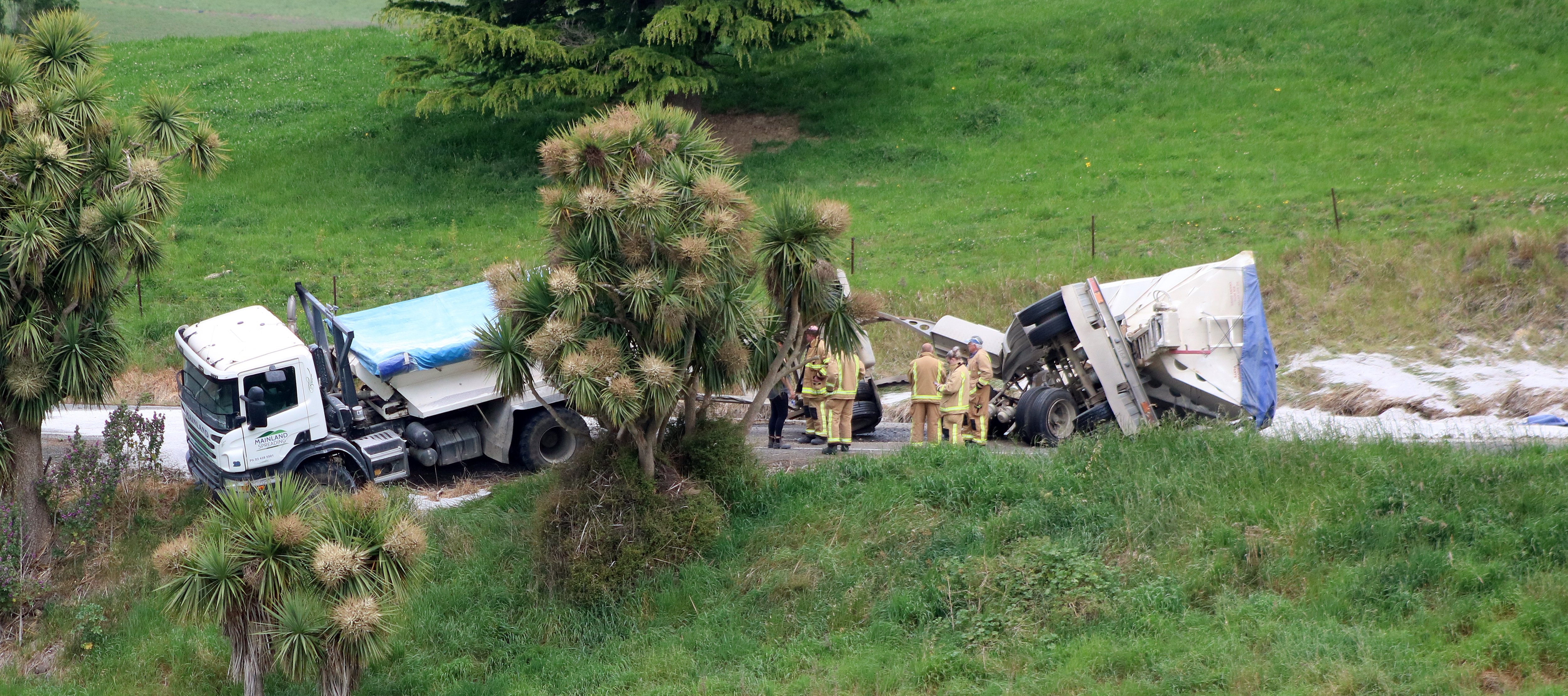 Firefighters work at the scene where a fertiliser truck crashed in Horse Gully Rd at Papakaio...