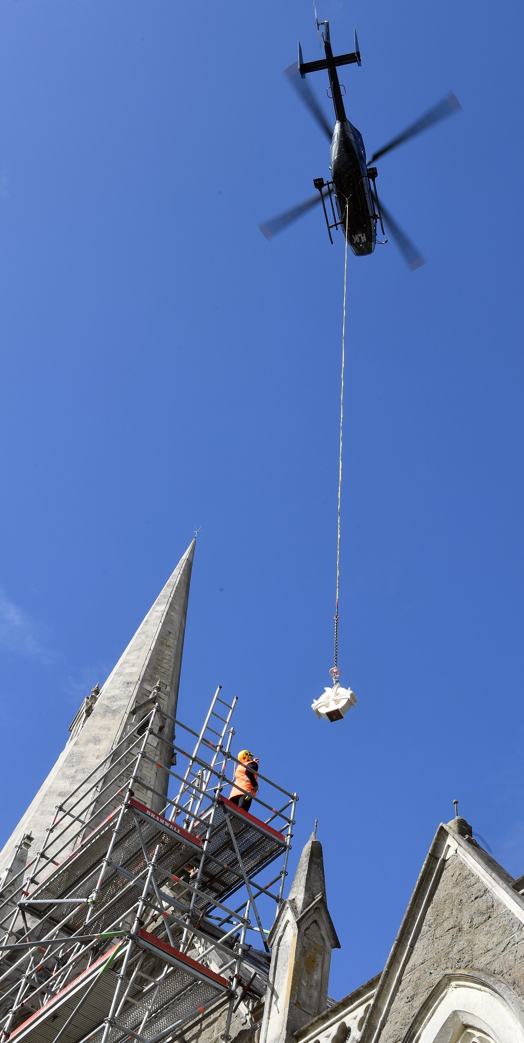 A helicopter was used to lift a freshly carved Oamaru stone cross to its new home on top of the...