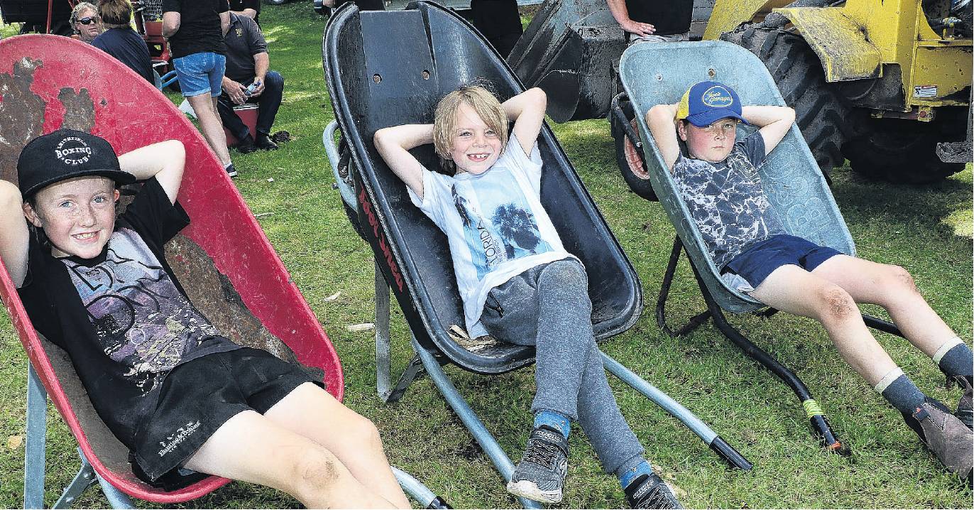 Taking a break . . . Resting in the shade between rounds of the axemen competitions were (from...