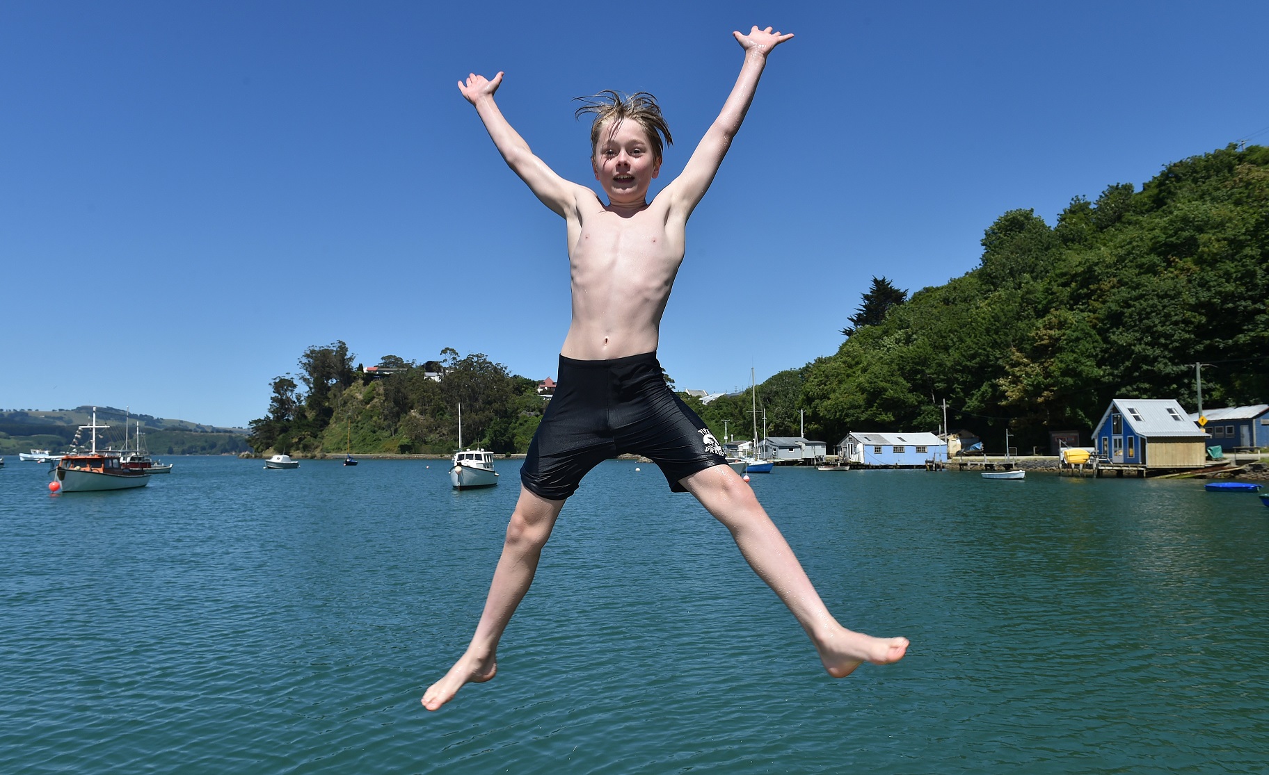 Tom Rae (12) of Dunedin jumps into the water off a jetty at Back Beach, Port Chalmers. Photo:...