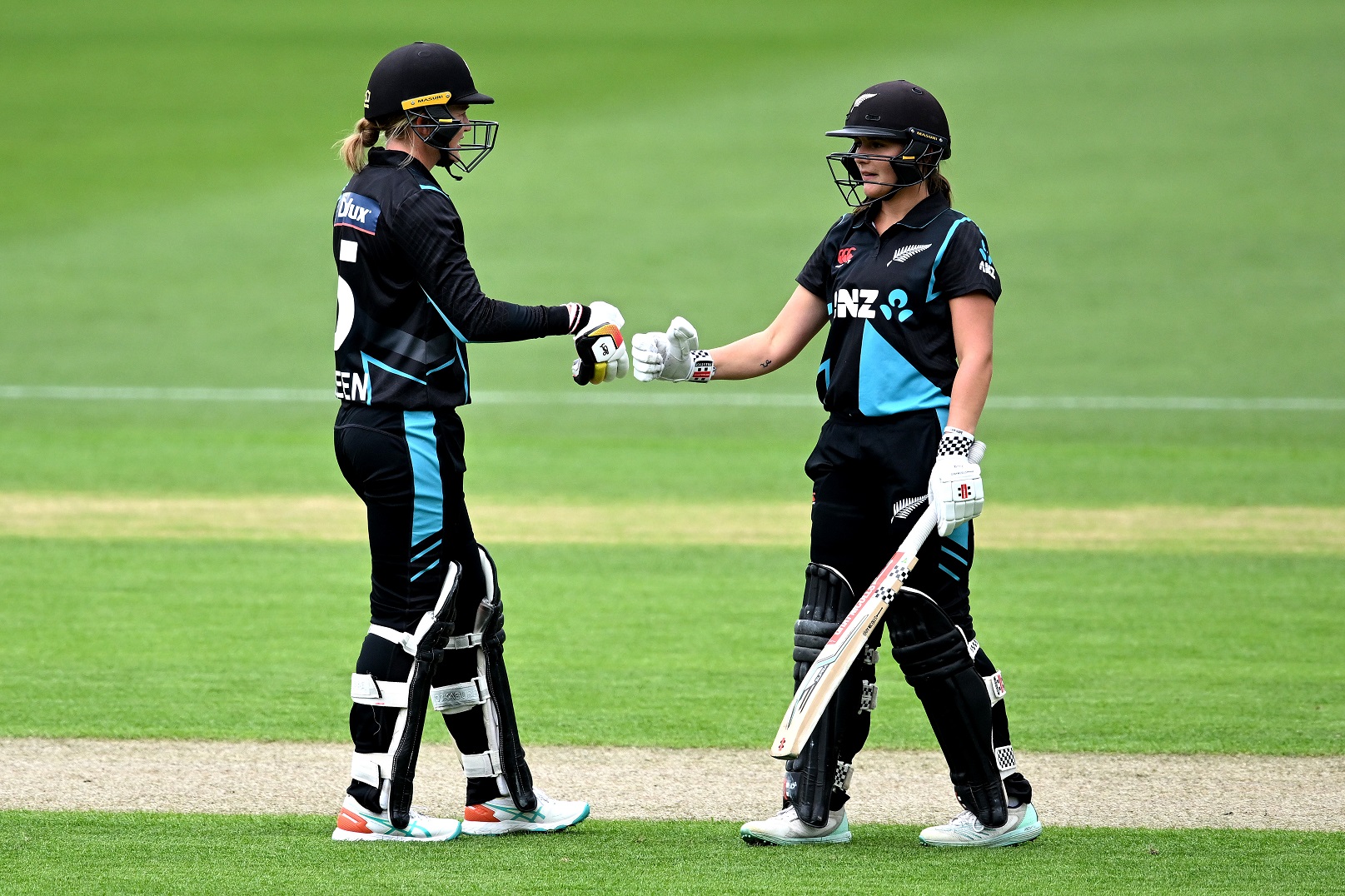 Maddy Green and Amelia Kerr of the White Ferns touch gloves during their unbroken partnership of...