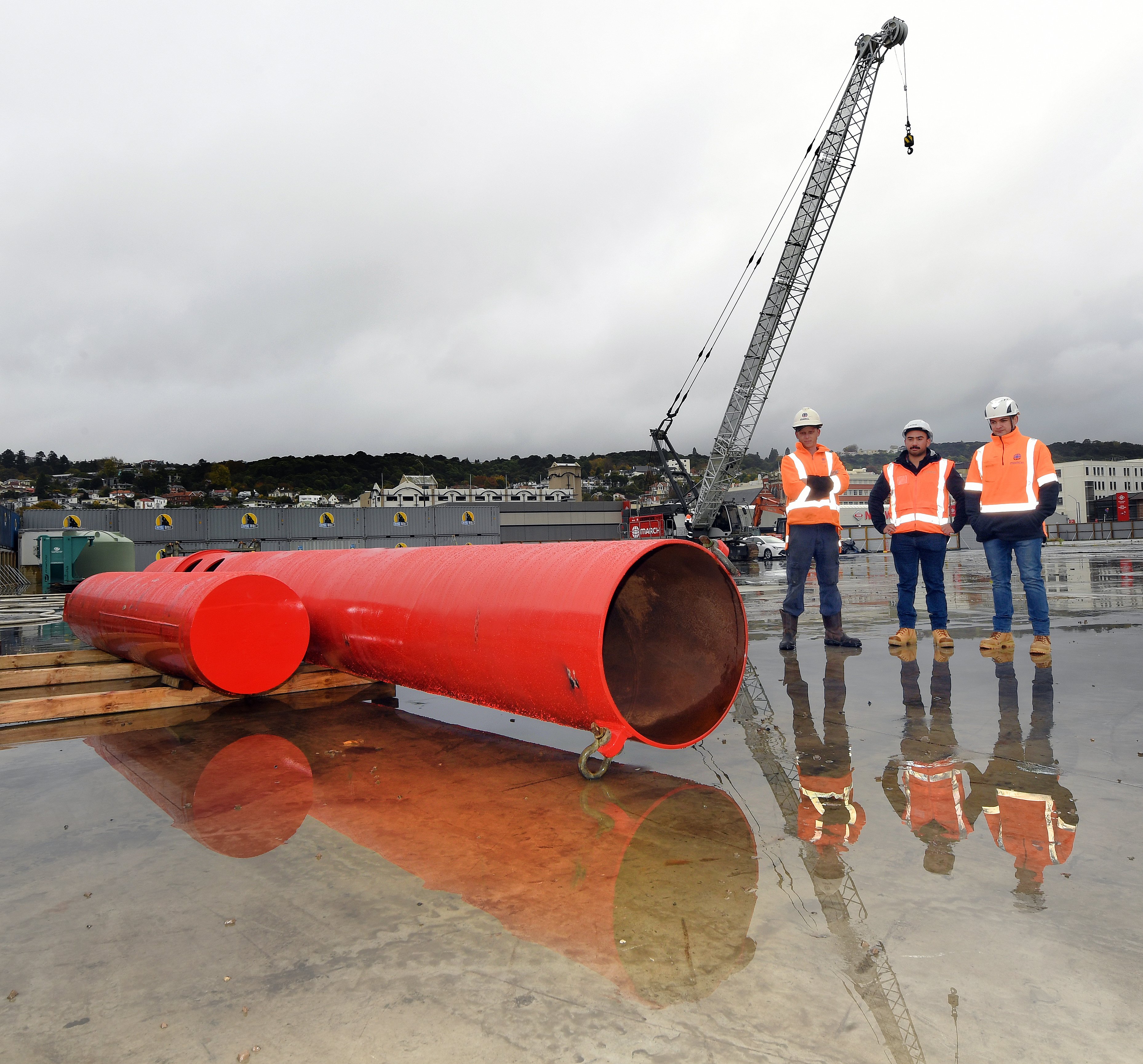 Standing beside the unnamed 14-tonne pile driving hammer yesterday are (from left) site...