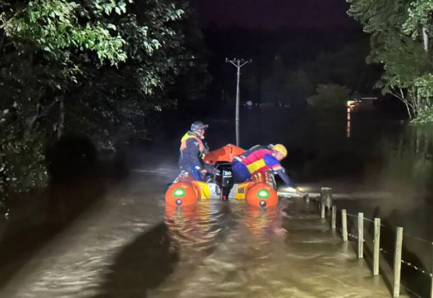 The crew said the scene at an 80-year-old woman's flooded home was like a "disaster movie". Photo...