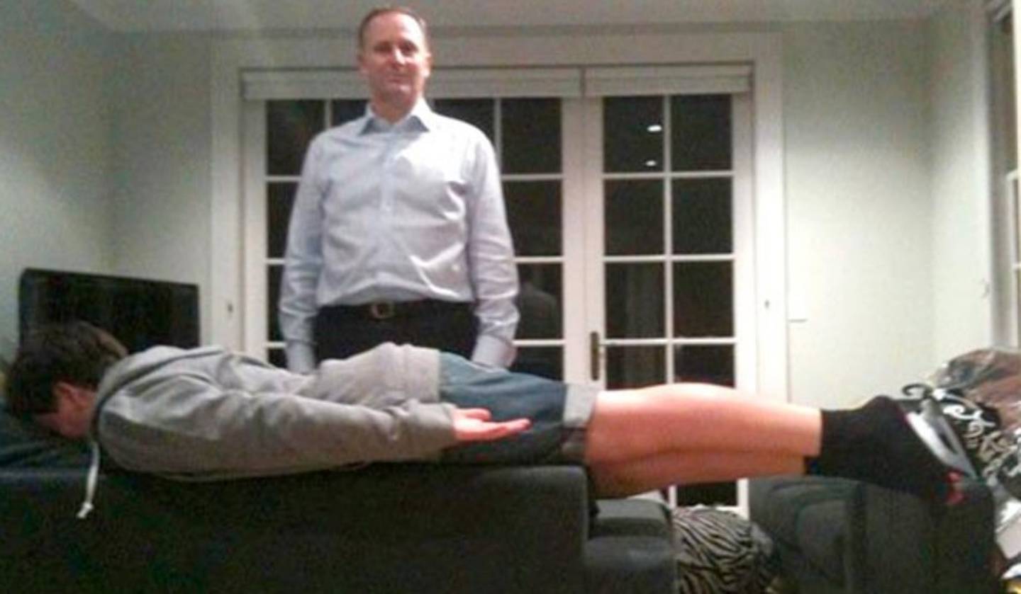 John Key's son, Max, makes his "PM plank" while his father stands behind him, creating what one...