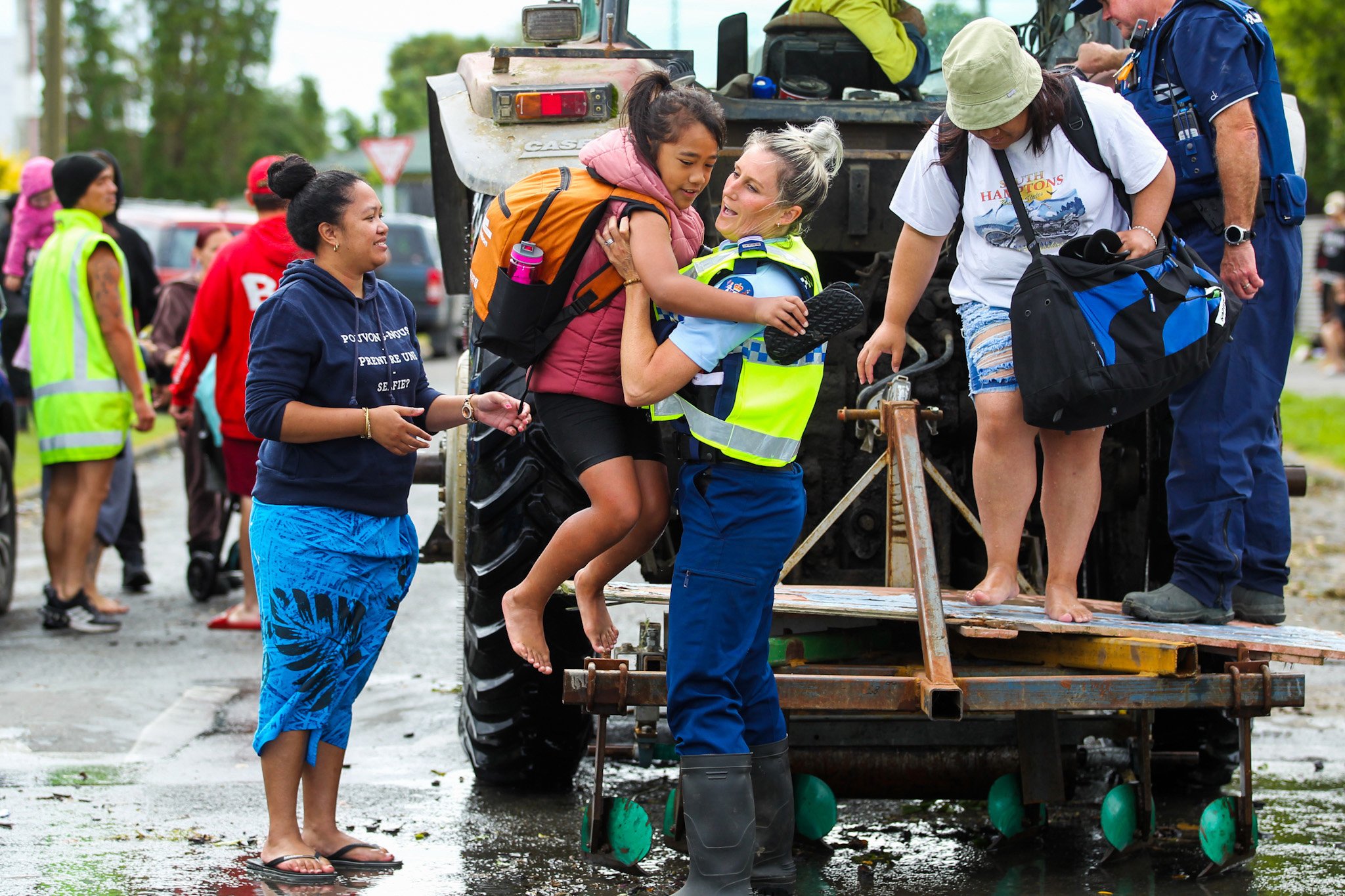 A policewoman lifts a child from the back of a tractor during an evacuation in Napier yesterday....