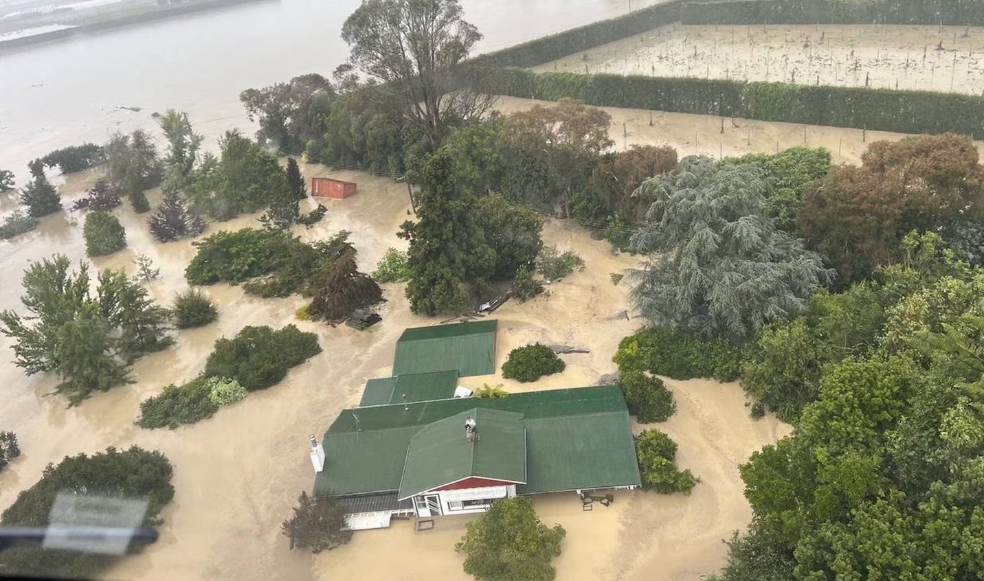 A resident in Esk Valley near Napier waits to be plucked to safety by Defence Force personnel in...