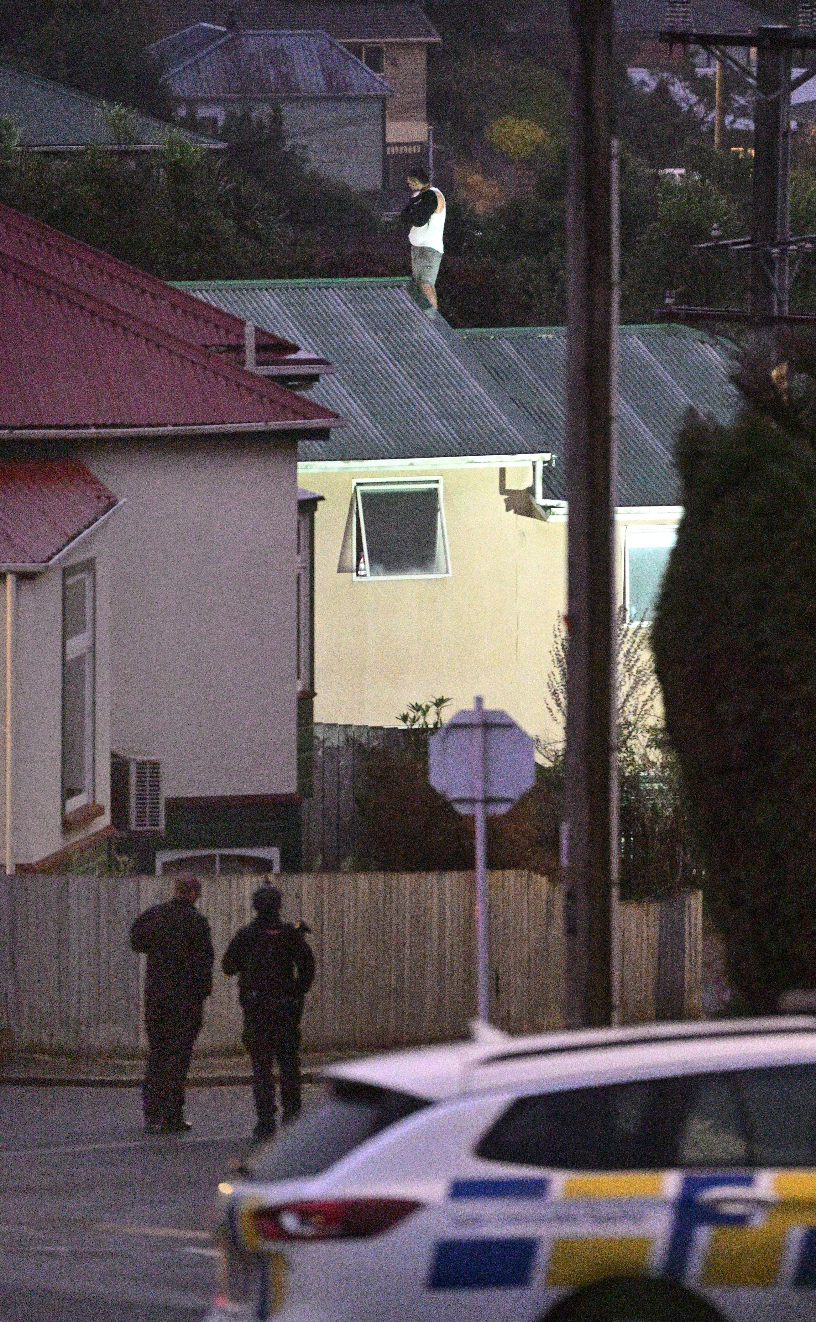 Armed police at the cordon in Neidpath Rd with the man at the centre of the siege on the roof in...