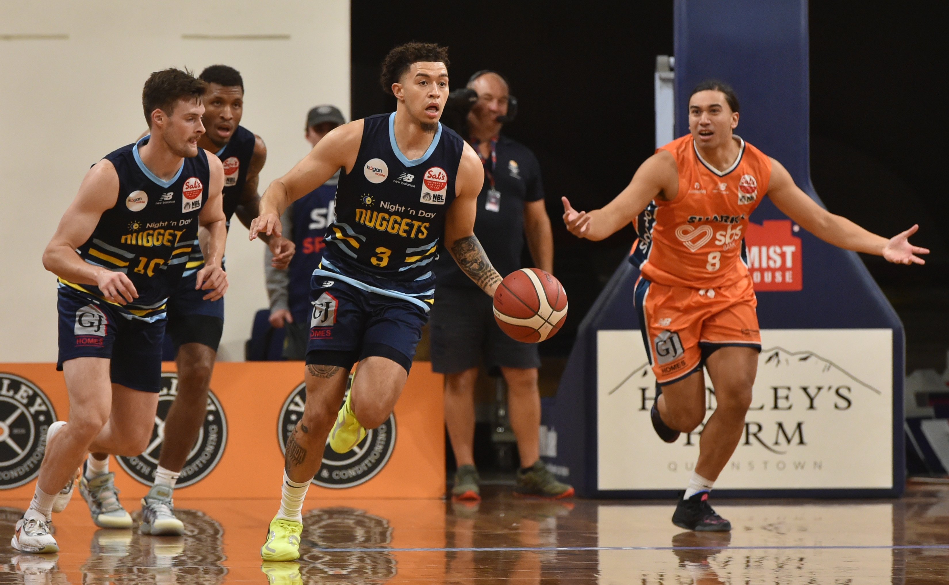 JaQuori McLaughlin carries the ball down the court, flanked by Otago Nuggets team-mates (from...