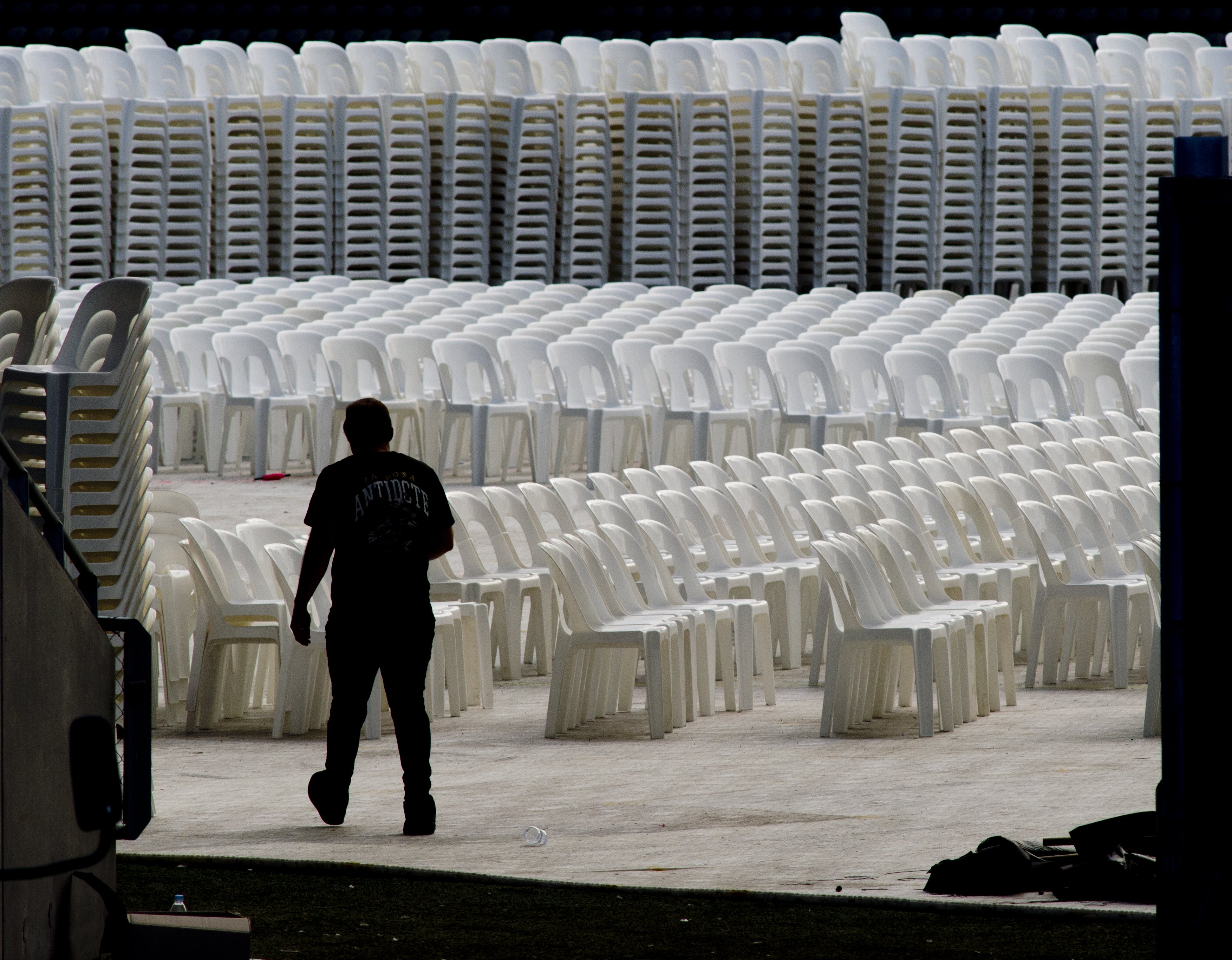 A worker walks past seating being laid out at Forsyth Barr Stadium yesterday, in preparation for...