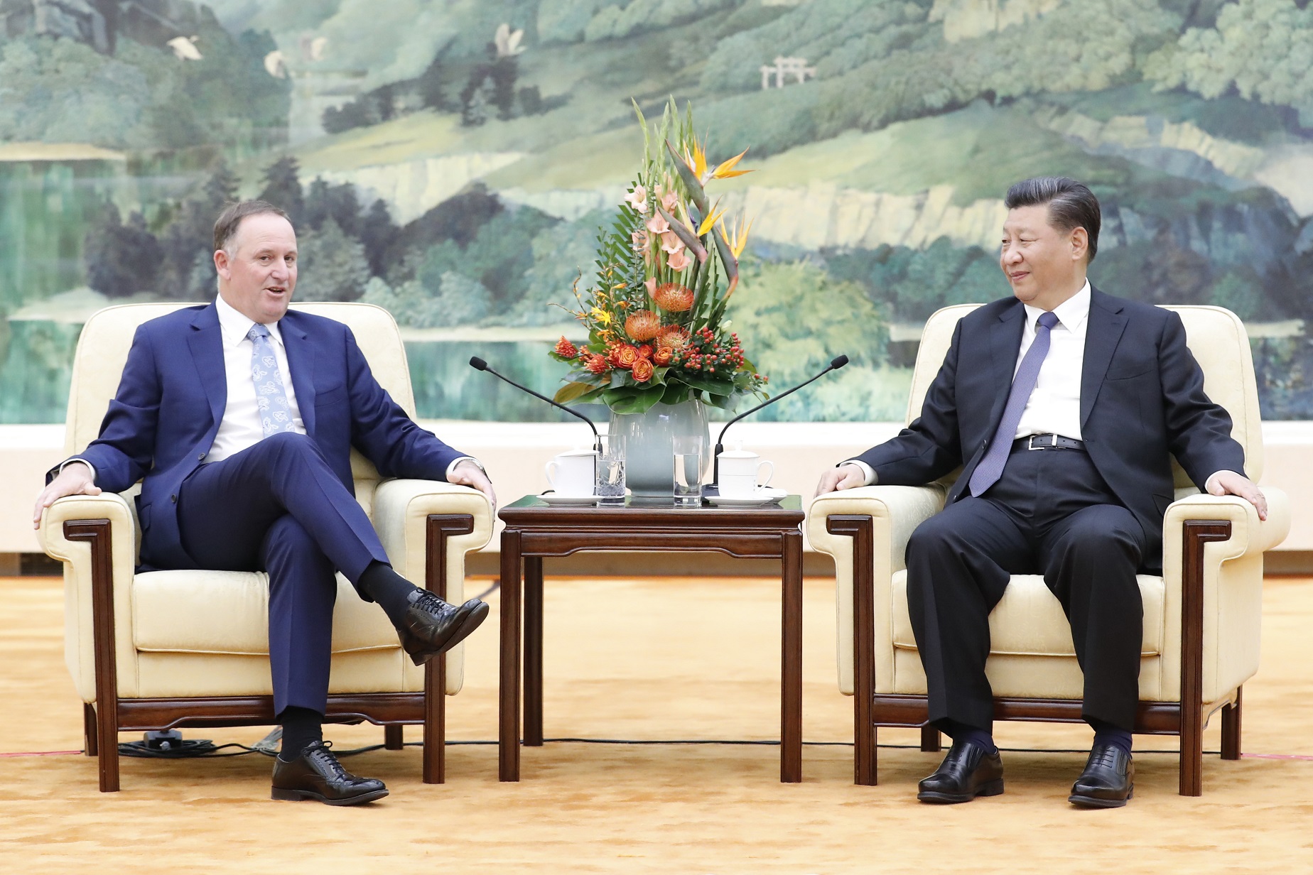 China's President Xi Jinping sits with former New Zealand Prime Minister John Key during a...