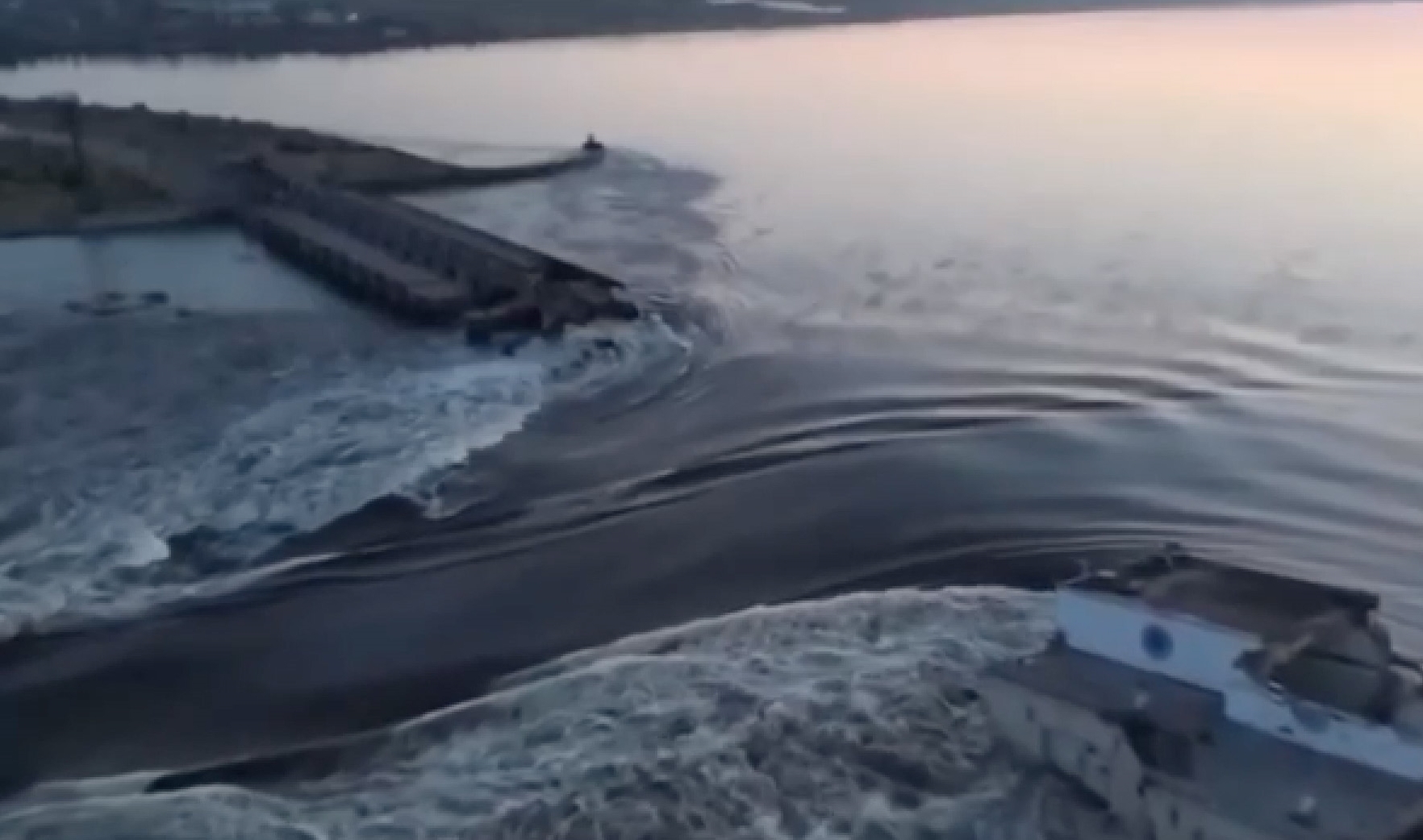 Water pours through the Kakhovka Dam in Ukraine, flooding large swaths of residential and...