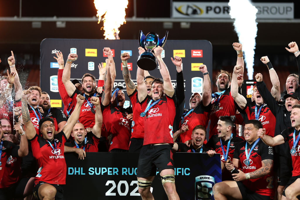 Crusaders captain Scott Barrett holds the Super Rugby Pacific trophy as the team celebrates...