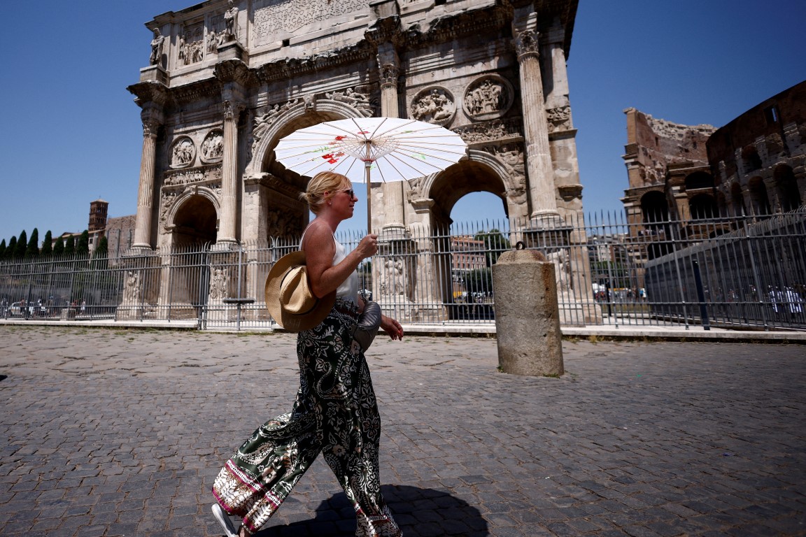 A woman walks near the Colosseum in Rome as the temperature nears 40degC this week, Photo: Reuters