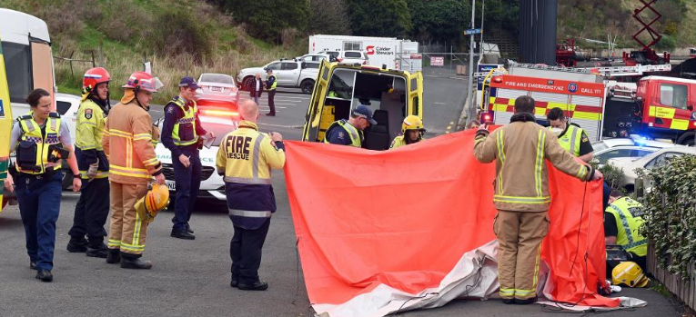 Emergency services hold up a privacy screen while attending an incident in Murrayfield St near...