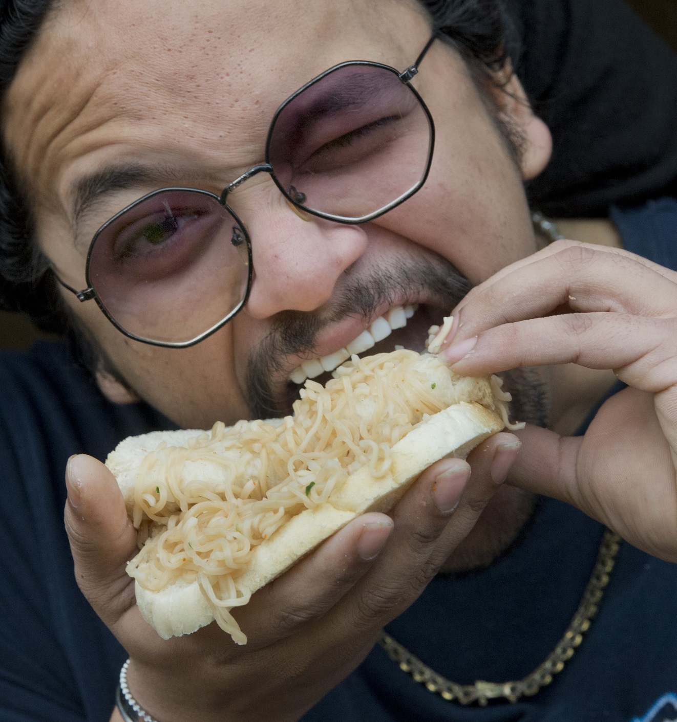 Abdulrahman Ali slurps up his noodle sandwich. Photo: Gerard O'Brien