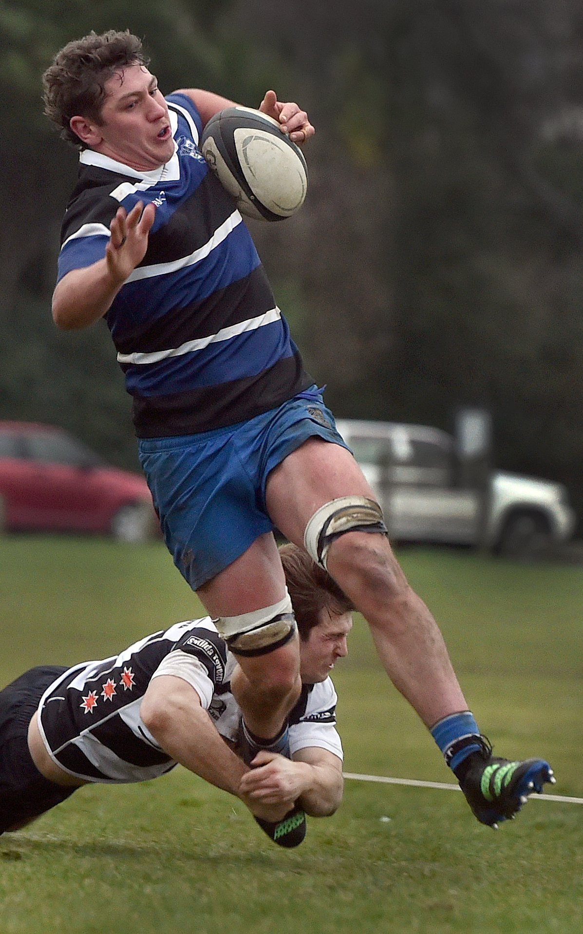 Kaikorai loose forward Lucas Casey tries to slip the tackle of Southern halfback Bailey Moody...