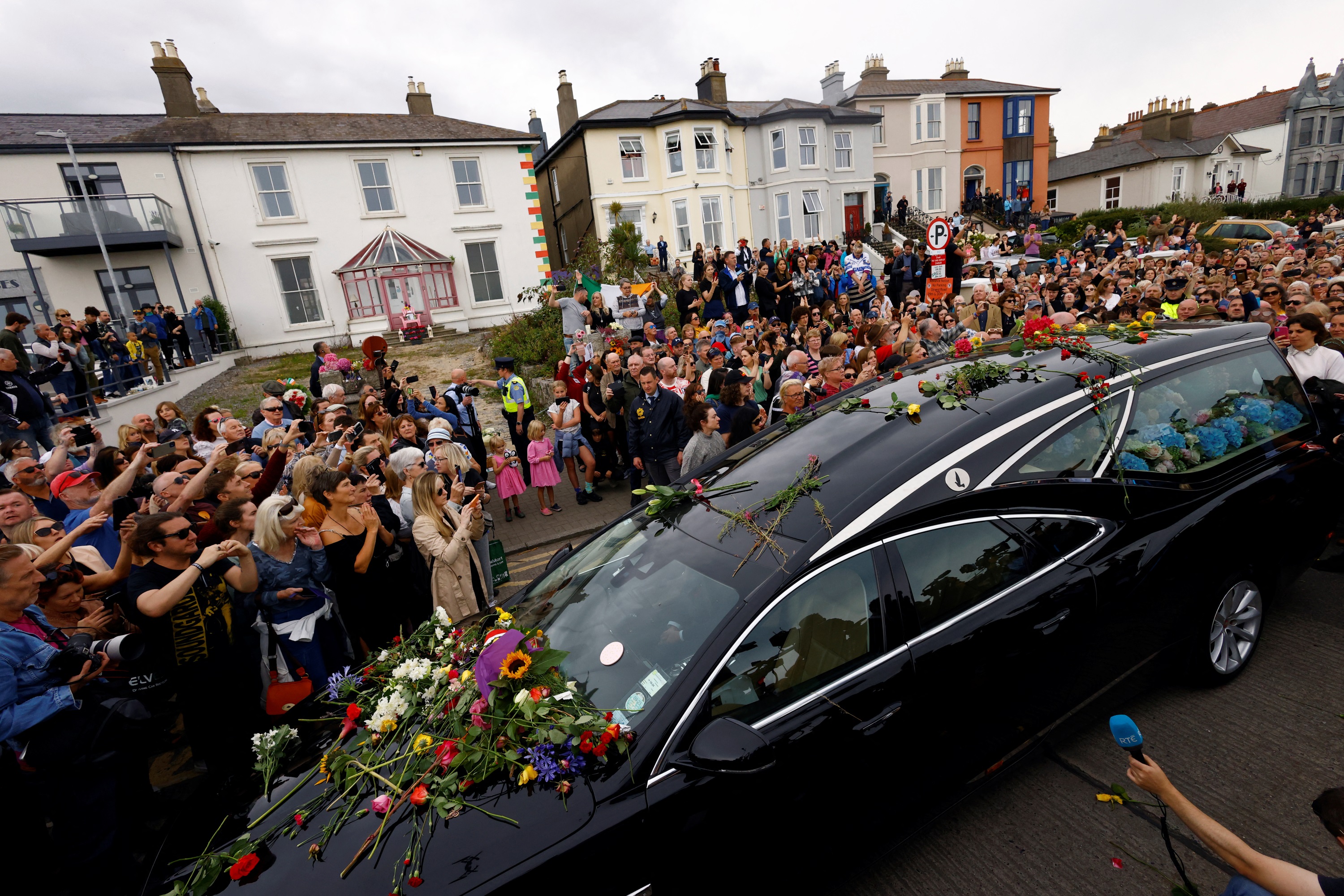 A hearse passes outside Sinead O'Connor's former home in Bray as fans lined the street to say...