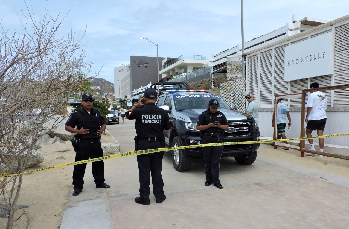 Police officers keep watch at an area closed in Cabo San Lucas as part of the security measures...