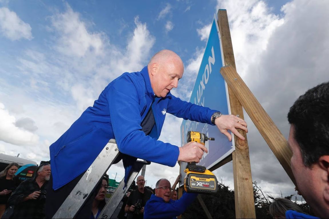 National leader, Christopher Luxon with the help of his dad Graham Luxon puts up the first...