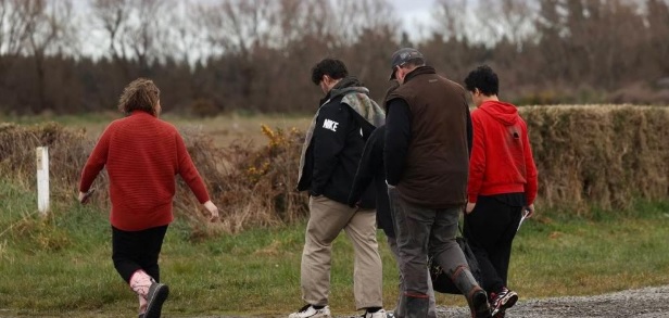 Three children are escorted from the crash site. Photo: NZ Herald