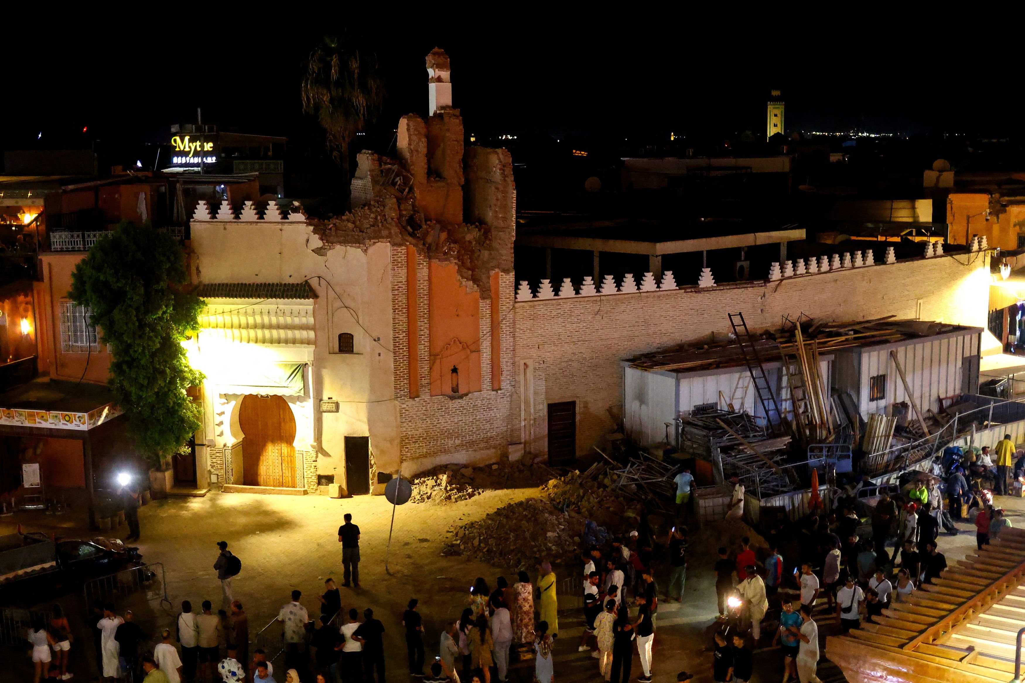 People gather next to a damaged building on a street in Marrakesh, following a powerful...