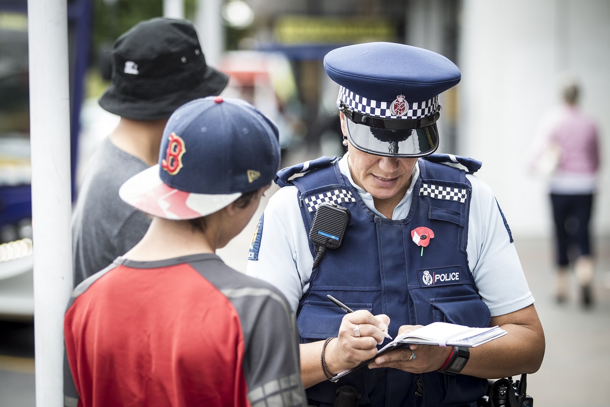 A police officer speaks to an Auckland boy out of school without permission. Photo: NZ Herald