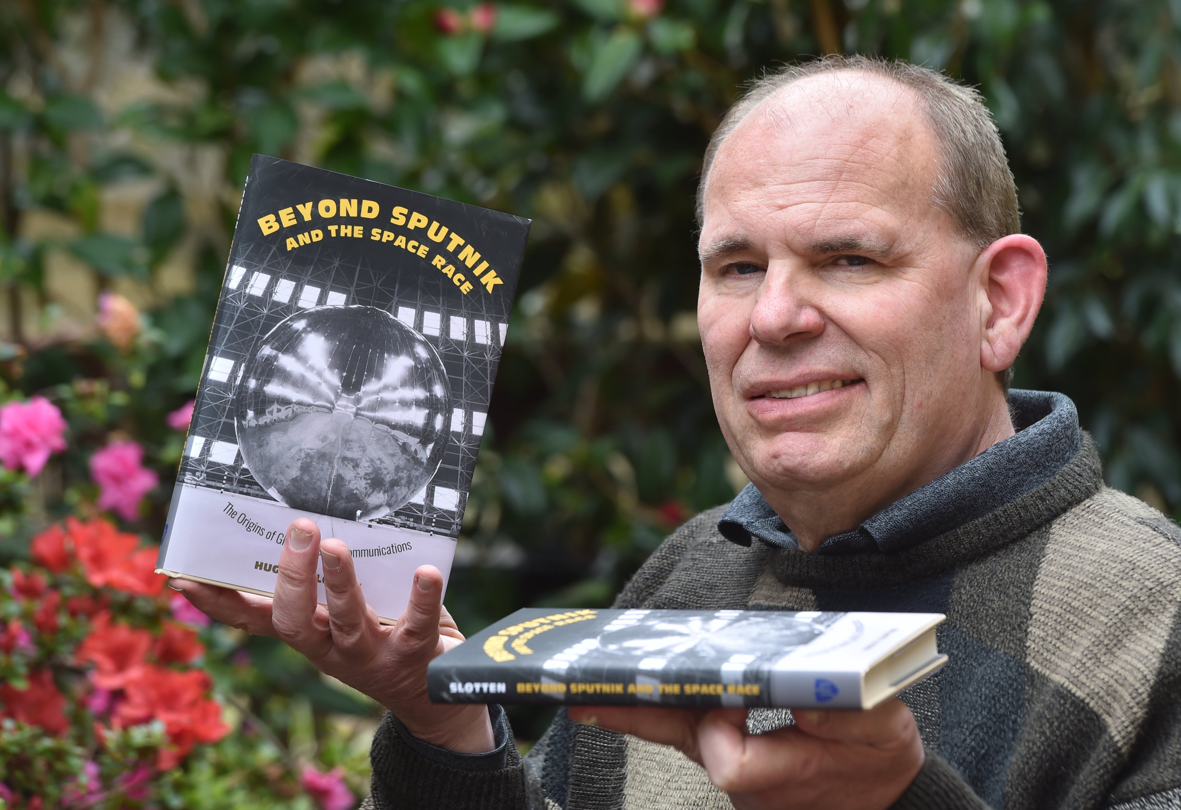 University of Otago Associate Prof Hugh Slotten holds copies of his award-winning book Beyond...