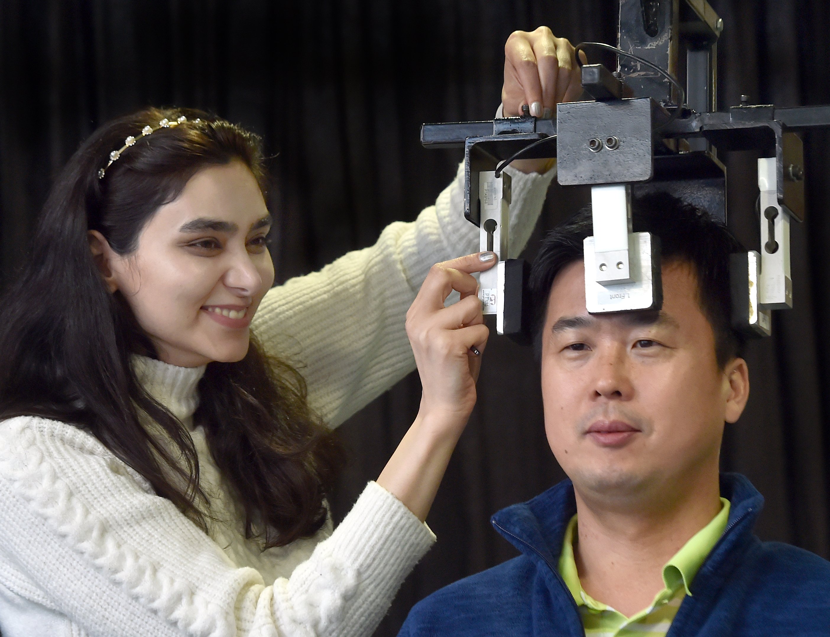 University of Otago PhD student Fateme Mirzaee uses a device to quickly test the neck muscle...