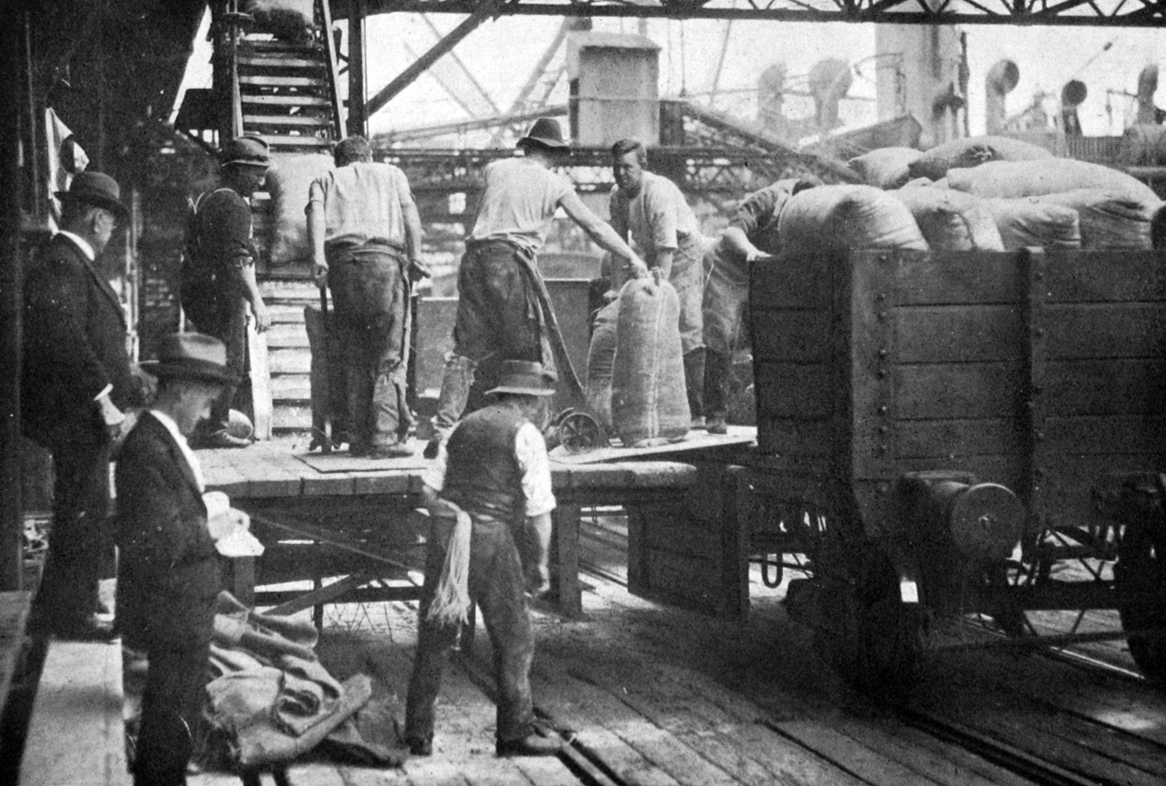 Workers at Sydney load the steamship Australmount with wheat sent by the Australian government...