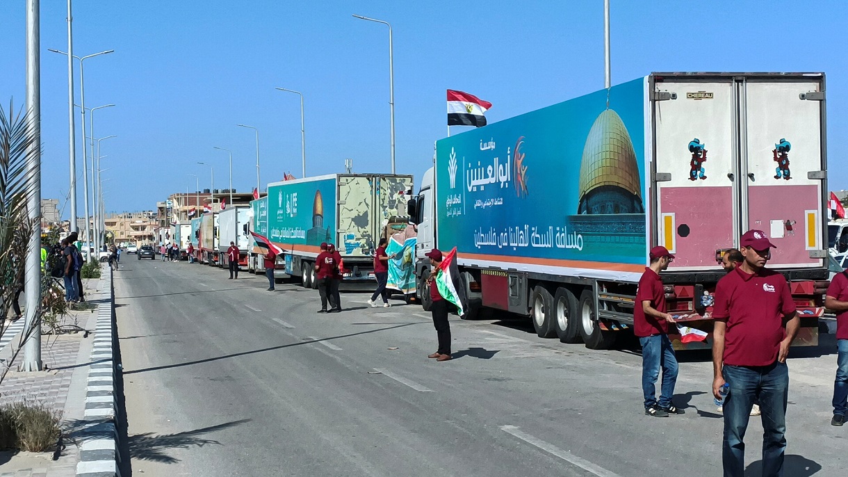 Volunteers in the city of Al-Arish in Egypt's Sinai peninsula wait next to a convoy of trucks...