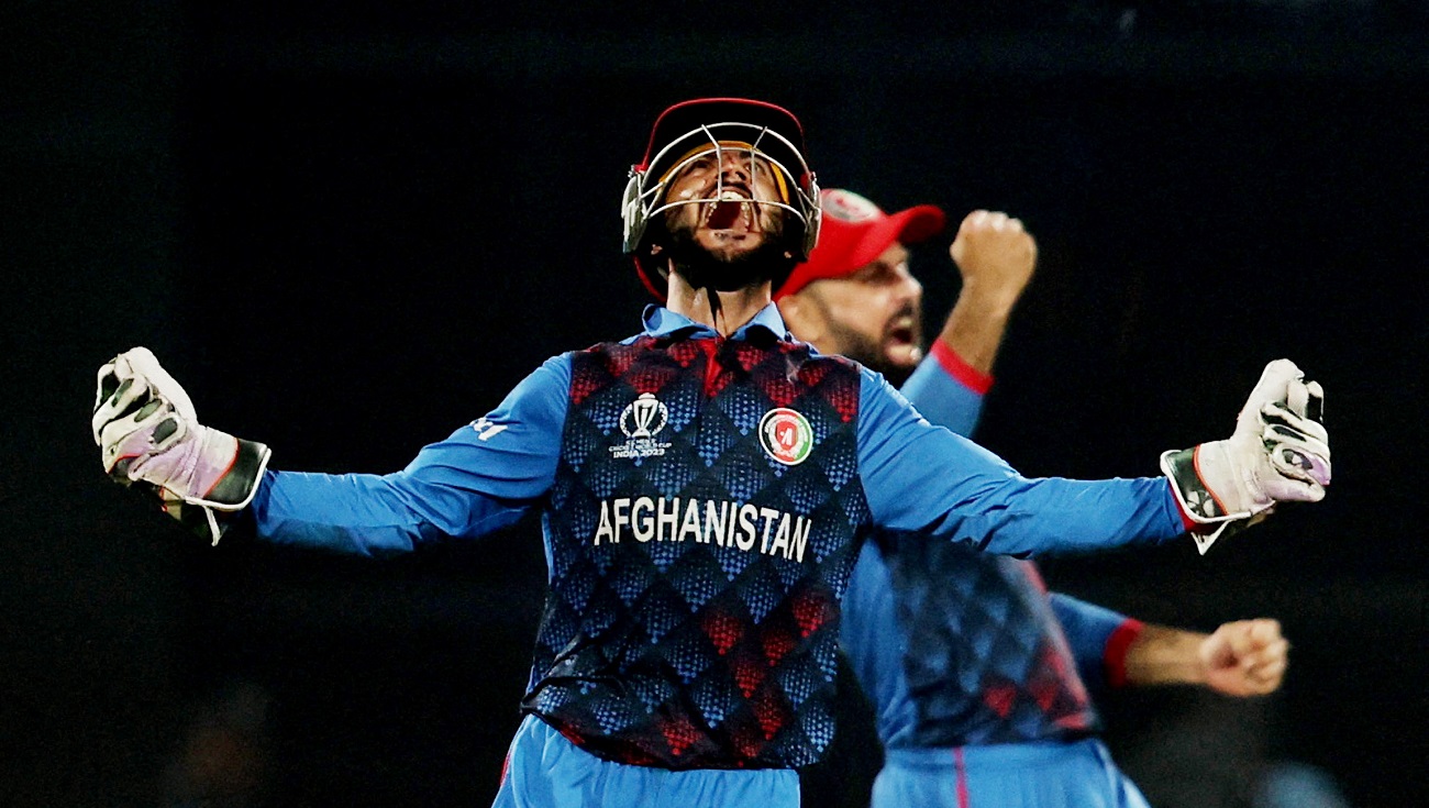 Afghanistan's Ikram Alikhil celebrates after Rashid Khan bowls out England's Mark Wood to win the...