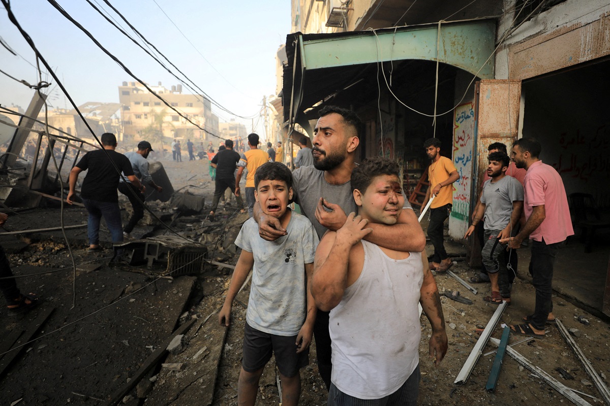 People react as Palestinians search for casualties at the site of an Israeli strike on a...