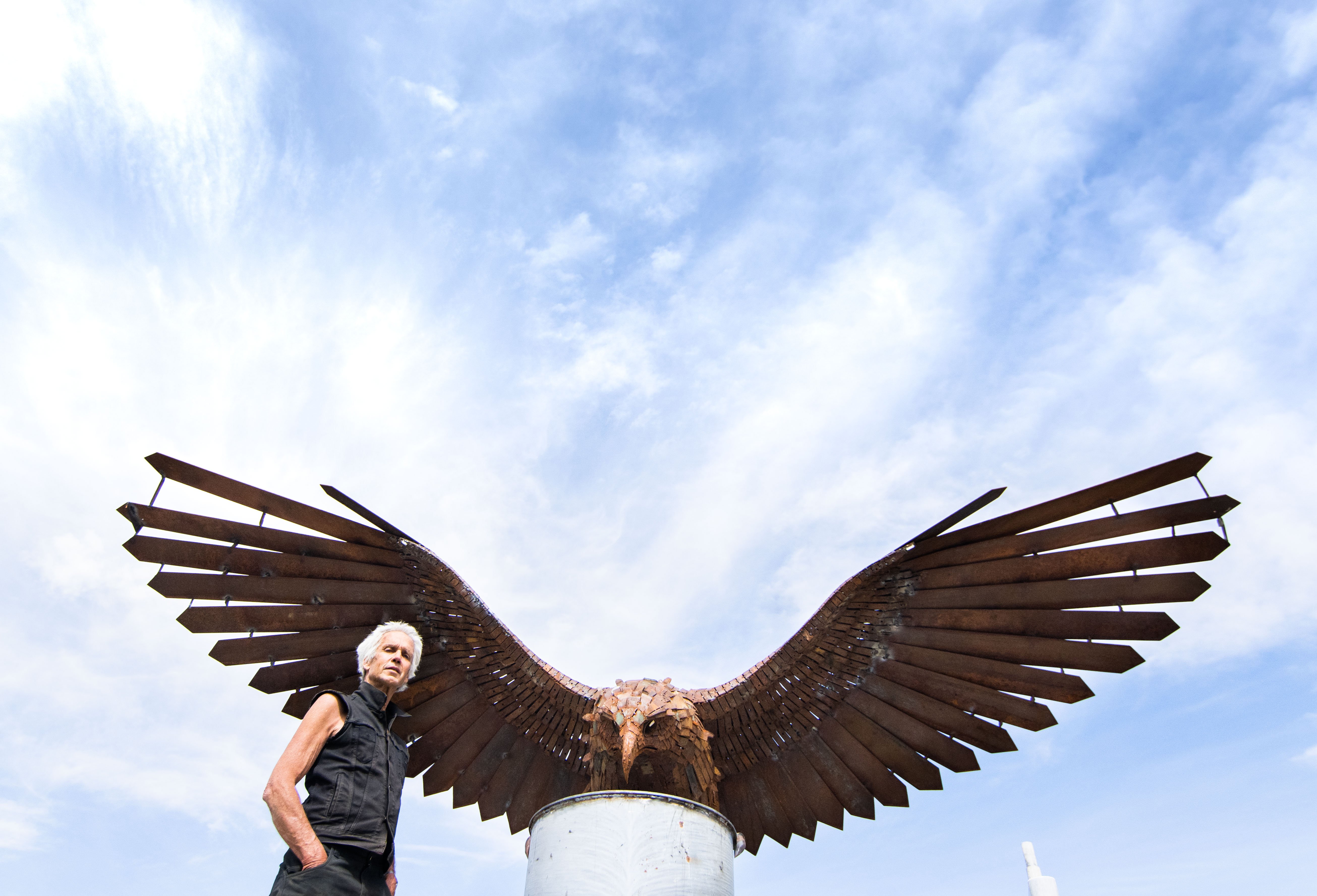 Glenorchy-based sculptor Dan Kelly with the kārearea sculpture he has installed near Clyde. PHOTO...