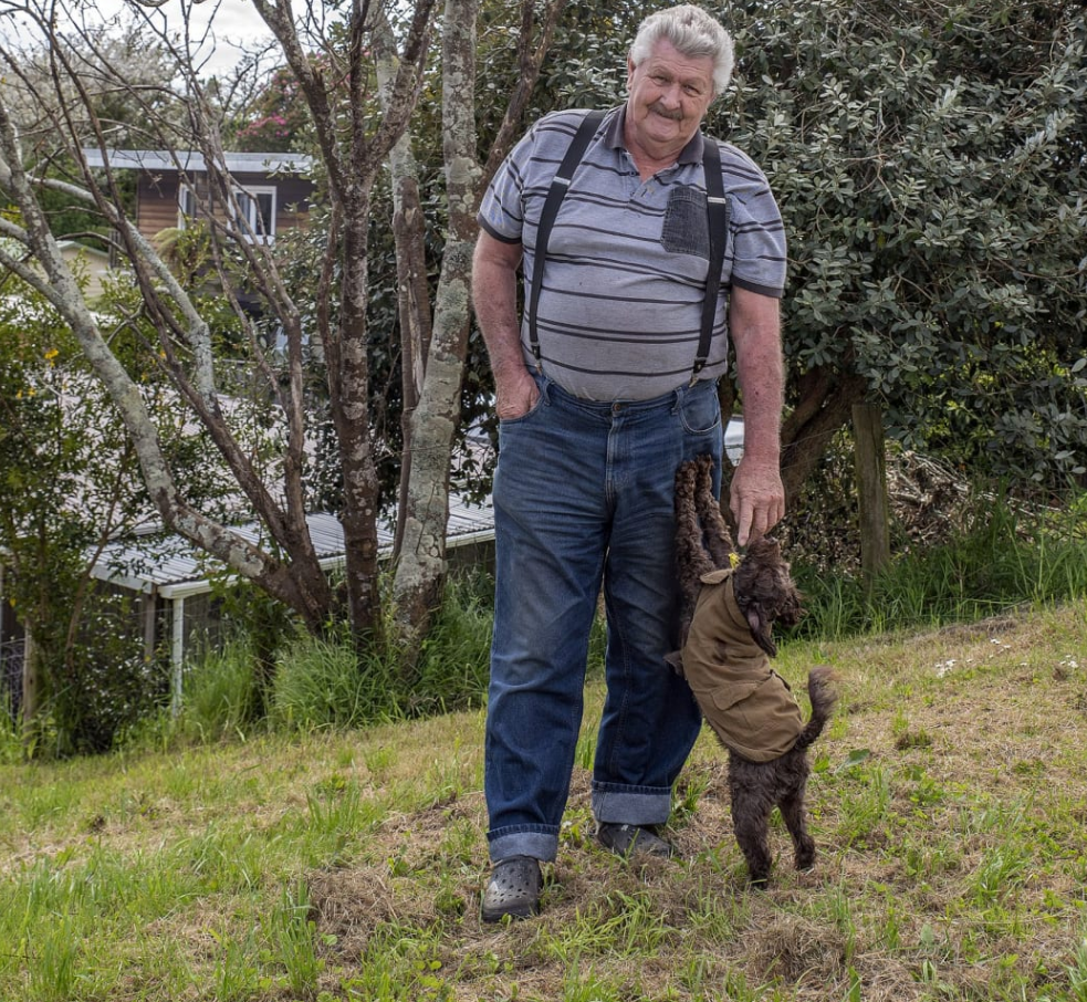 Don Meads and dog Banjo near the kōwhai planted on the stopbank behind his house. Photo: Local...