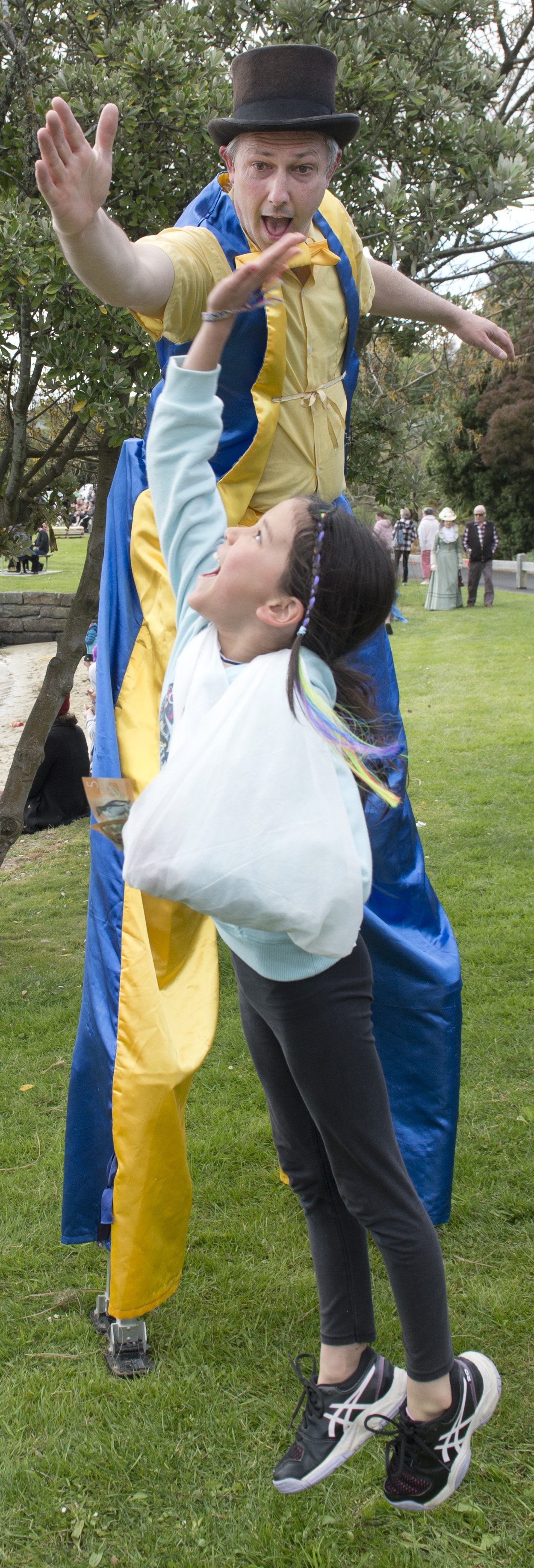 Arianna Mills, 8, meets stilt-walker "Miggles" (Miguel Weaver) at the Broad Bay Gala Day.